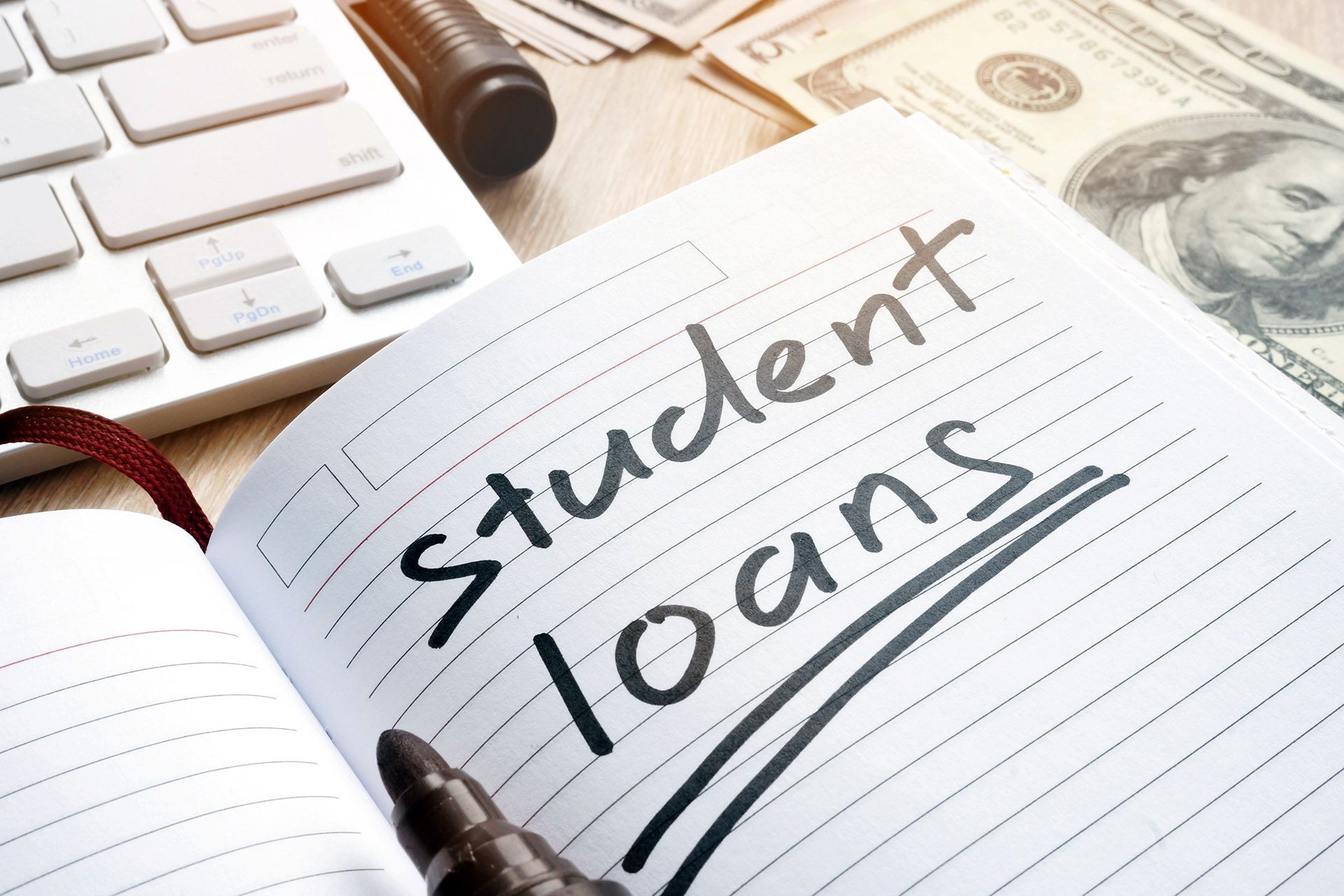 A notebook with the words “student loans” written on it.