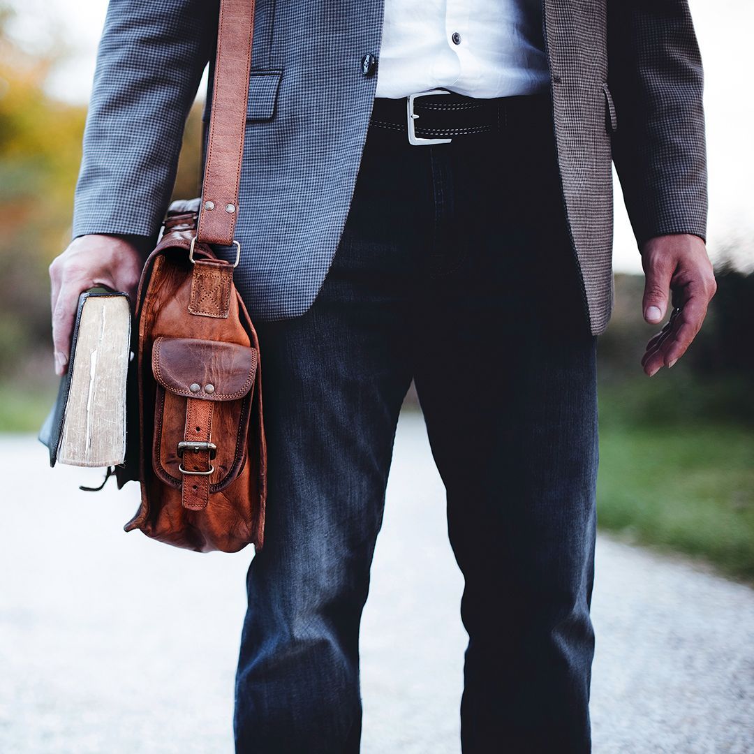 A business officer is carrying a Bible and a brown leather bag.