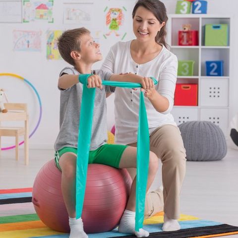 Boy Exercising on Ball with Therapist — Maitland, FL — Beckman & Associates Inc.