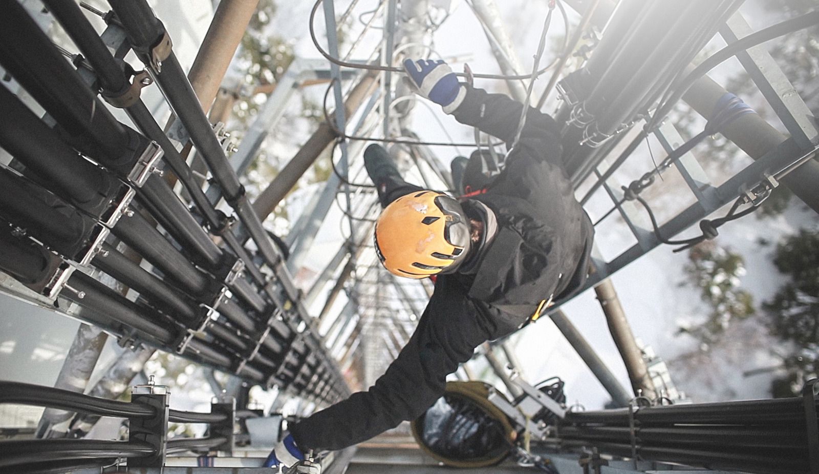 A man is falling down a ladder while wearing a helmet.
