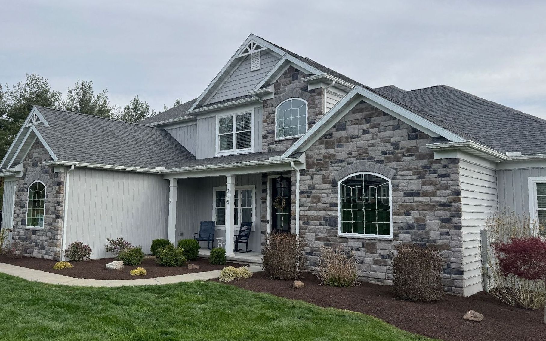 A person is riding a yellow lawn mower on a lush green field.