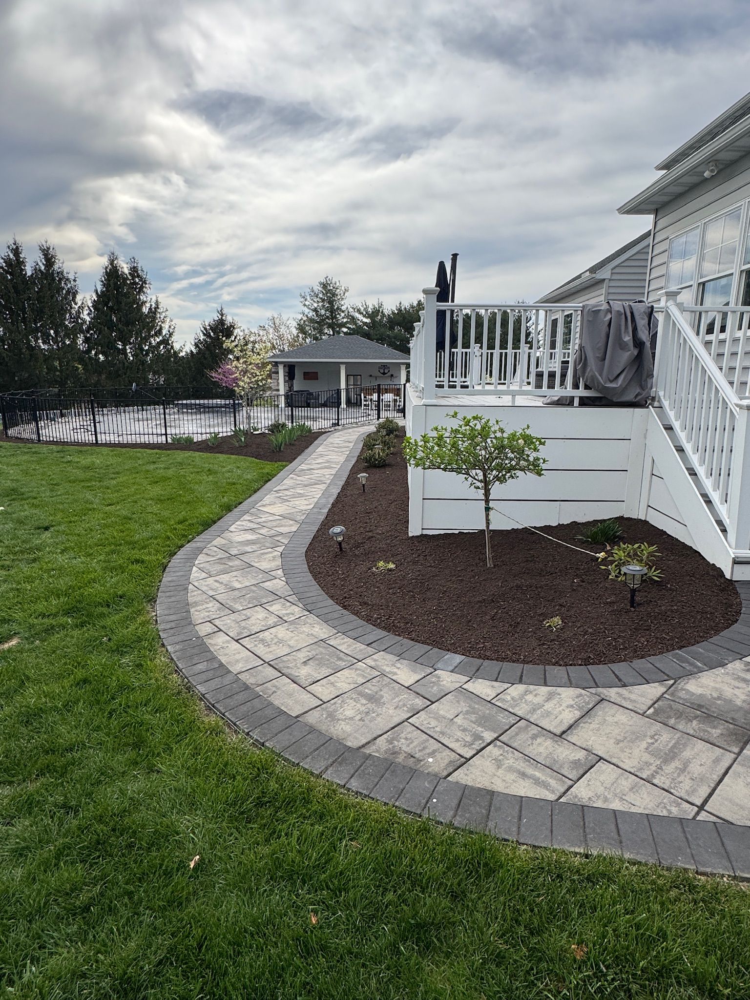 A large brick house with a large lawn in front of it.