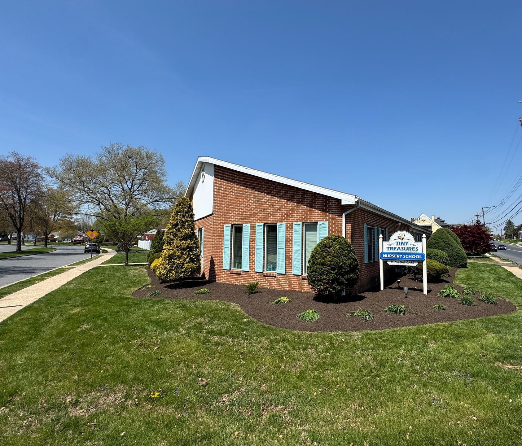 A laptop is sitting on a picnic table in a park.
