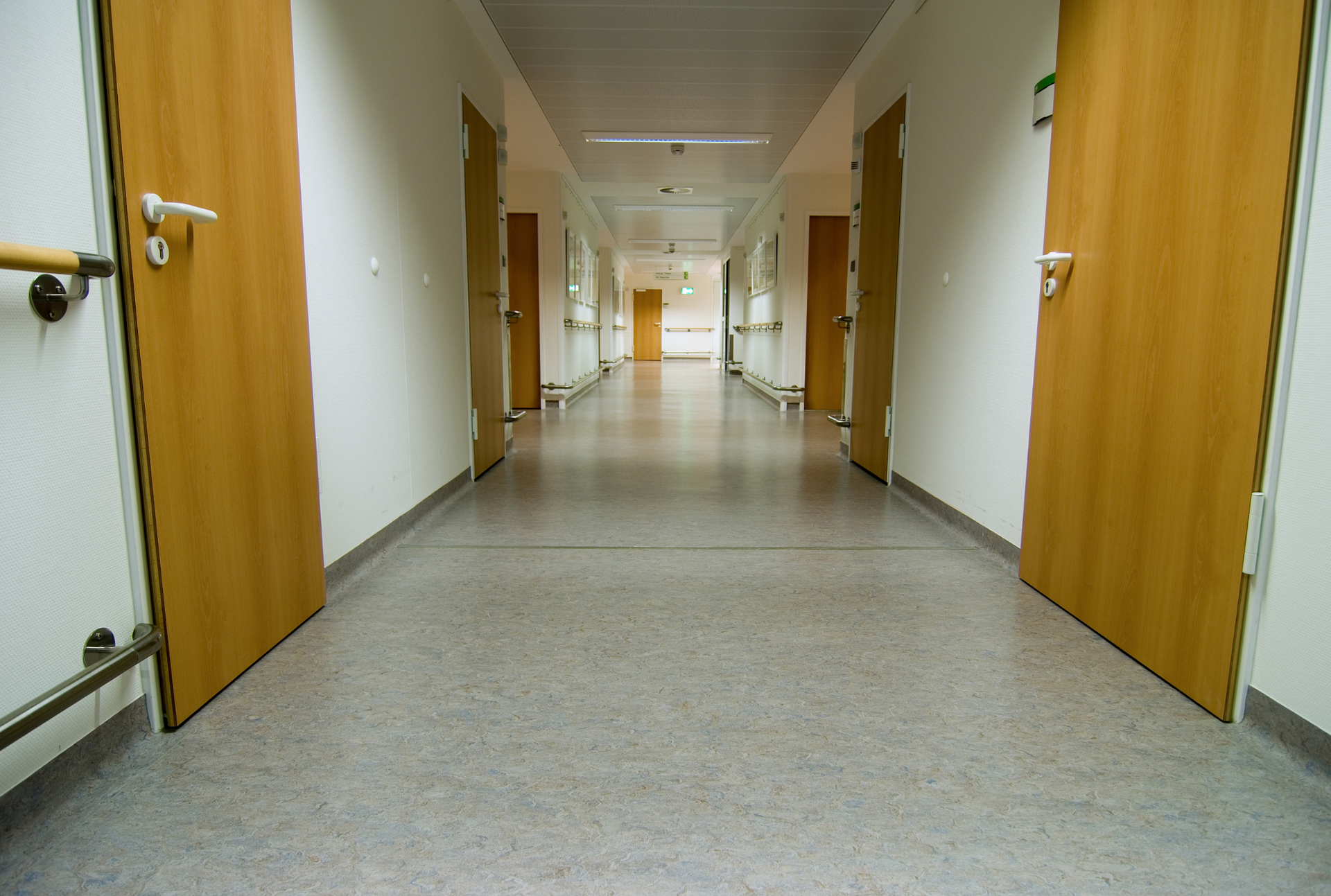 Long, empty hallway in a building with doors on both sides.