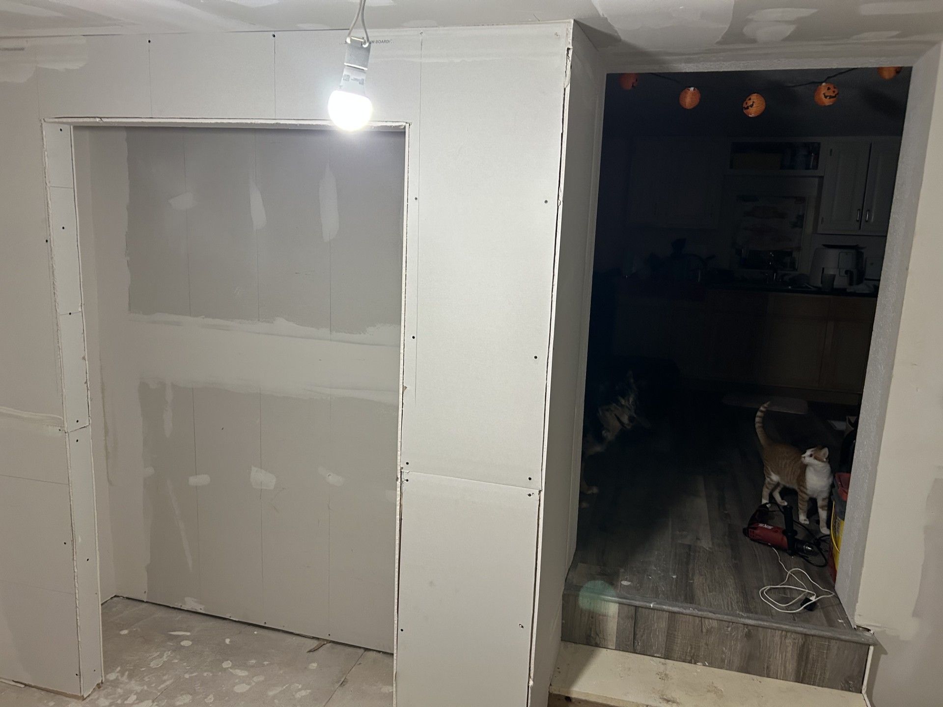 Woman in straw hat smiles, holding wine glass near a lake.