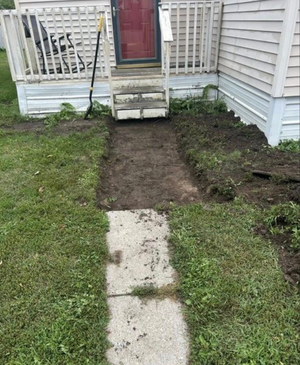 Woman in straw hat smiles, holding wine glass near a lake.