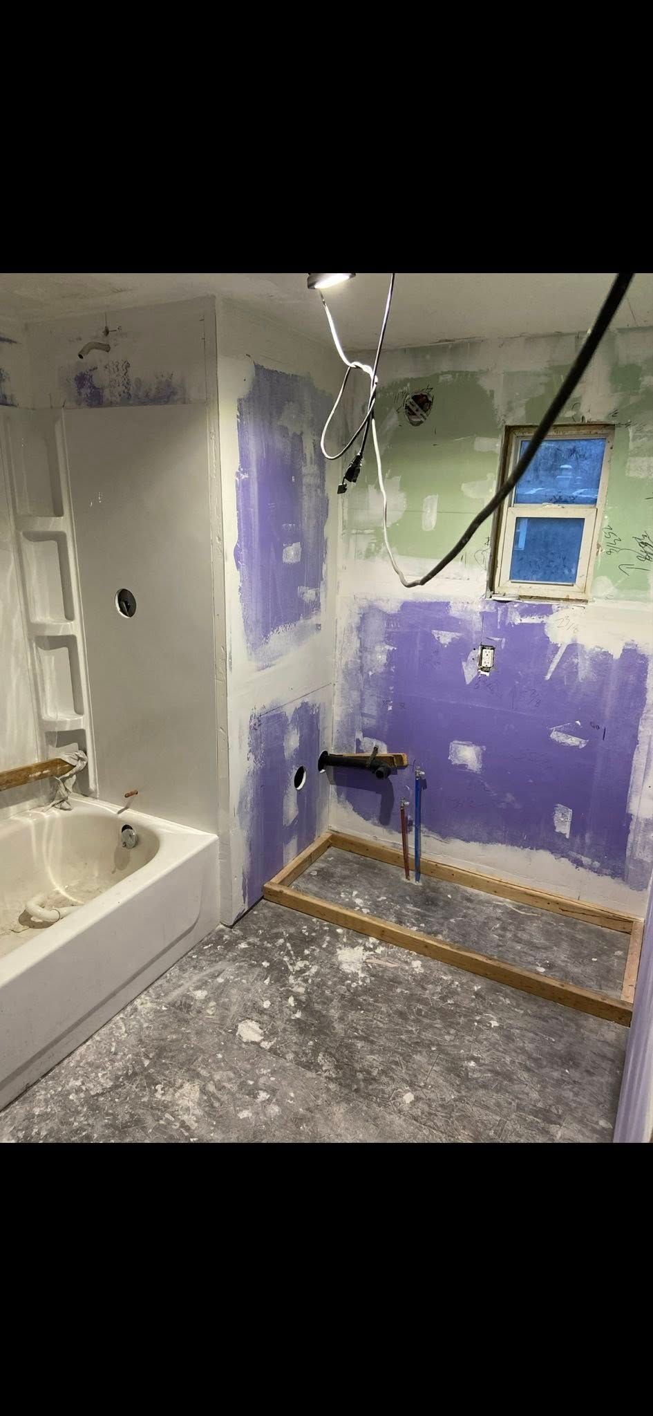 Woman in straw hat smiles, holding wine glass near a lake.