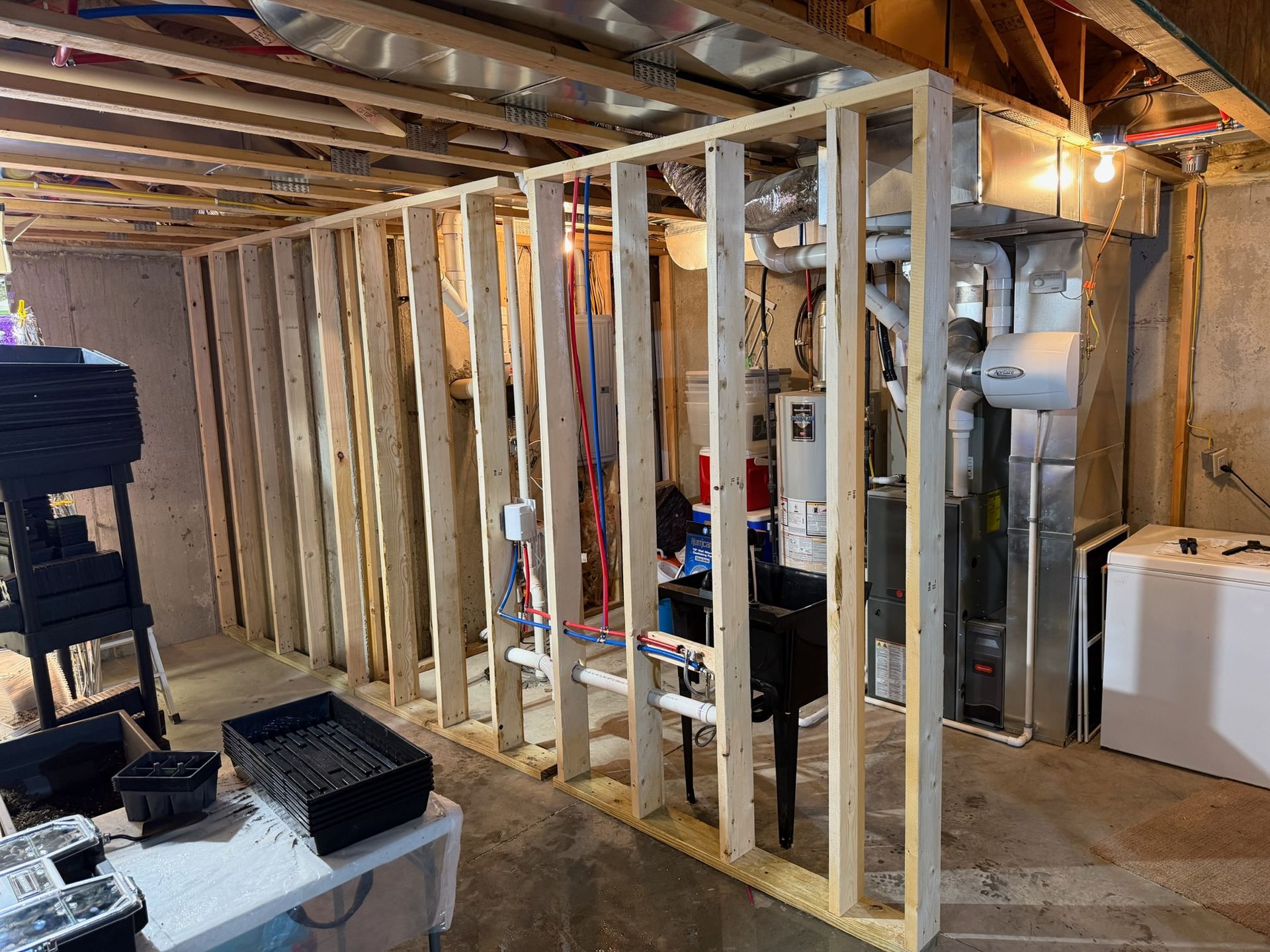 Woman in straw hat smiles, holding wine glass near a lake.