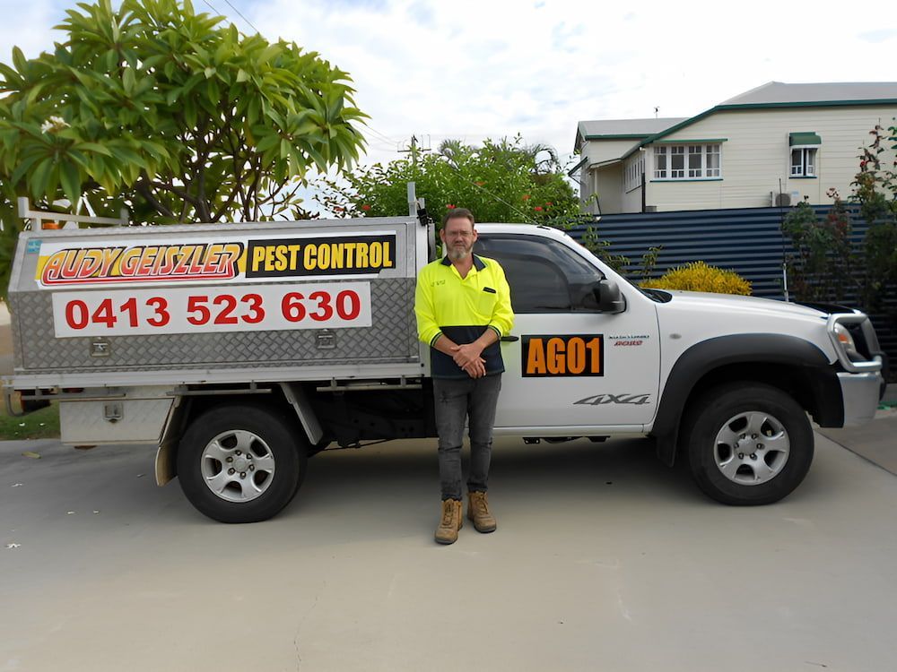 A Man Standing in Front of a White Truck That Says Ag01  — Audy Geiszler Pest Control in Bowen, QLD