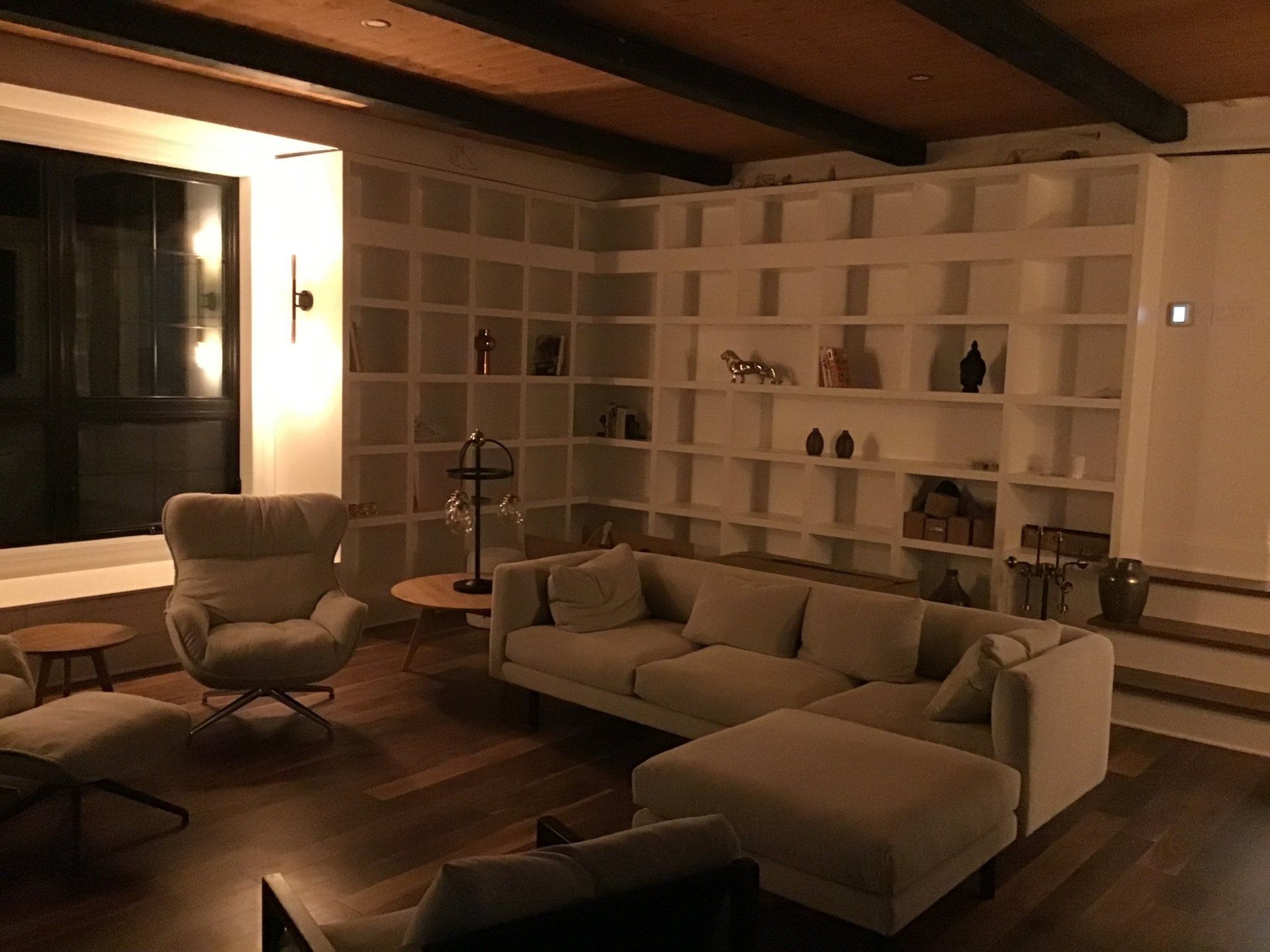 Un salon avec un canapé, une chaise, une table et des étagères.