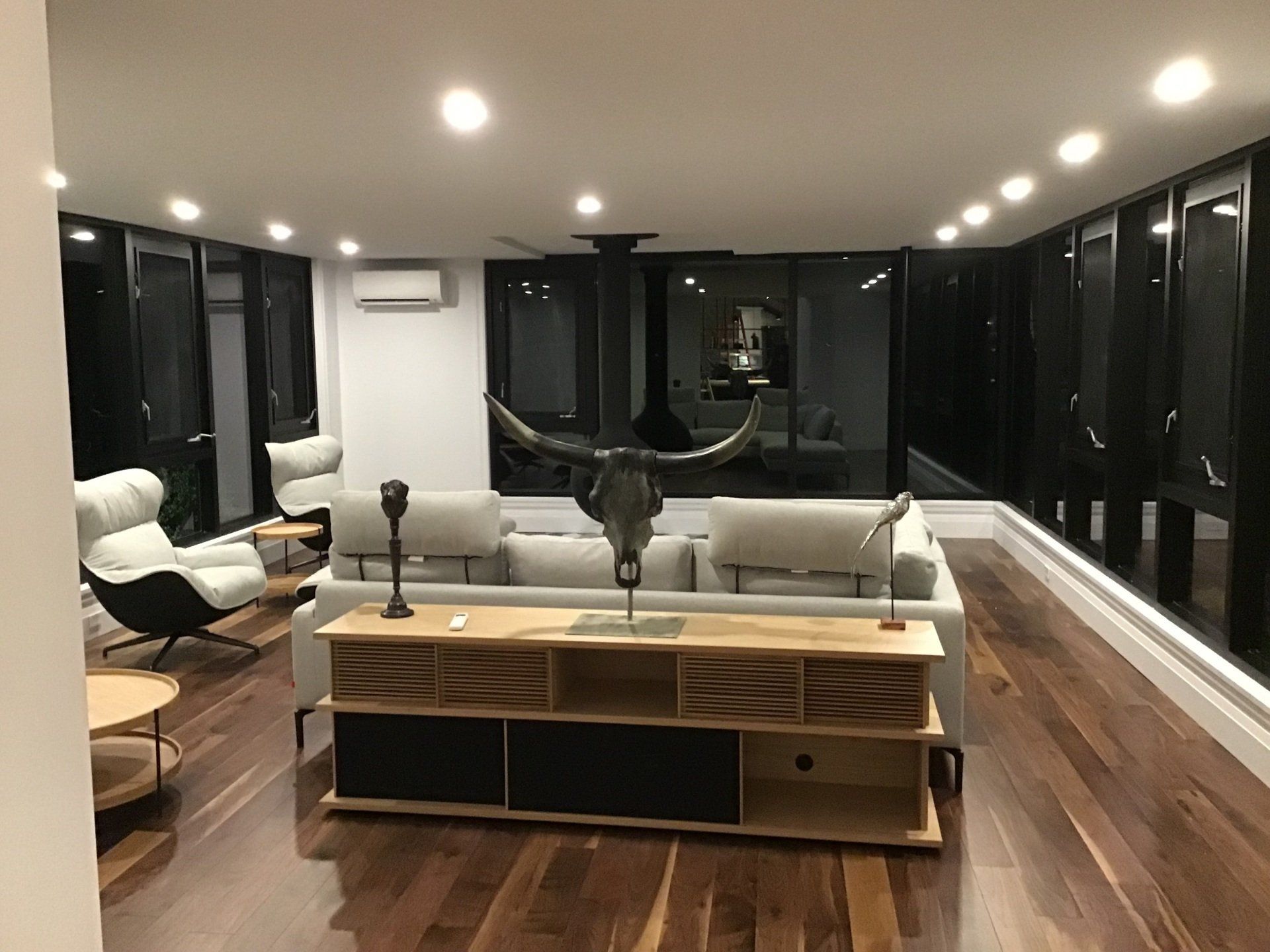 Un salon avec un canapé, des chaises et une statue de taureau.