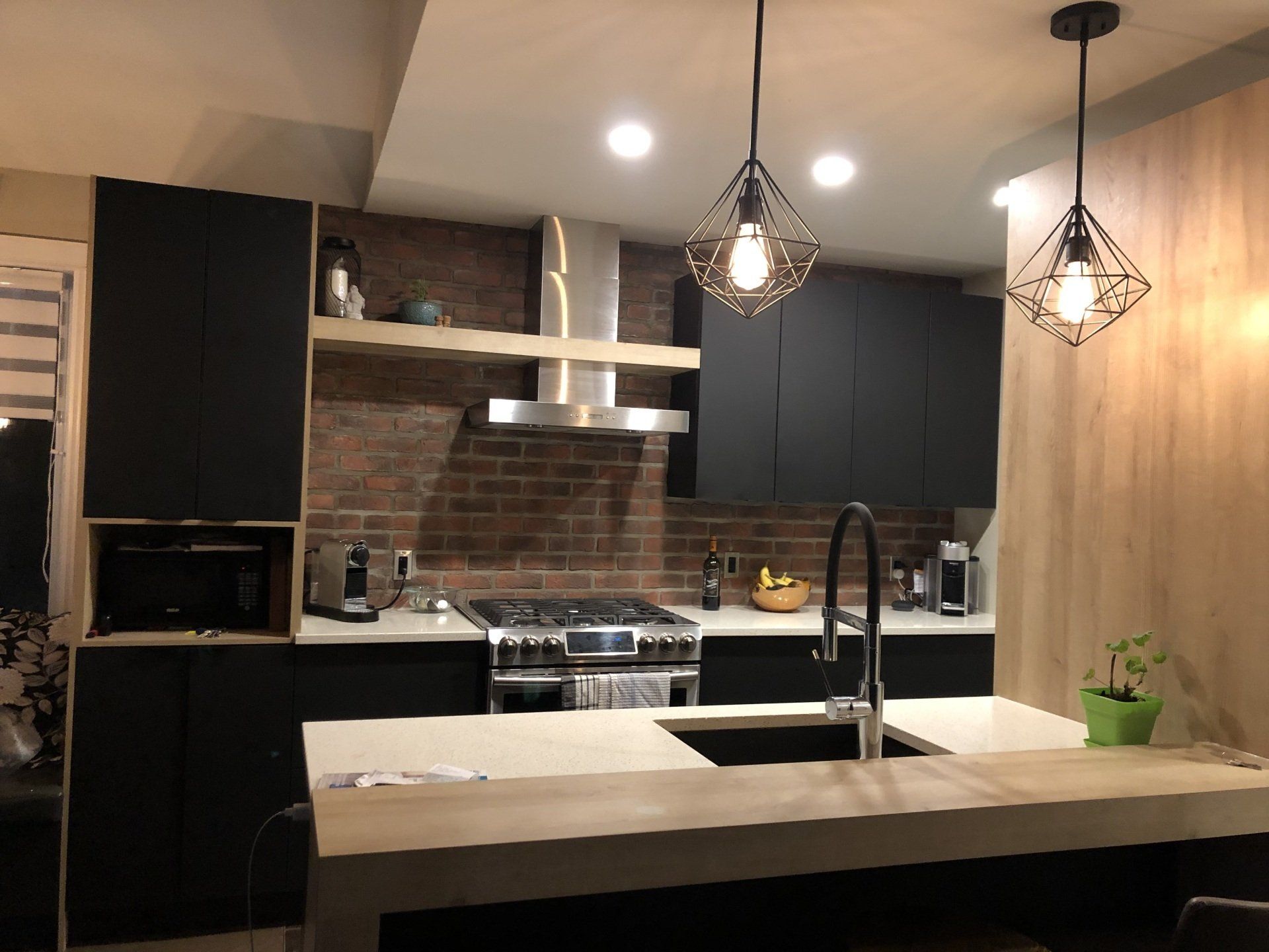 Une cuisine avec des armoires noires et un four sur la cuisinière