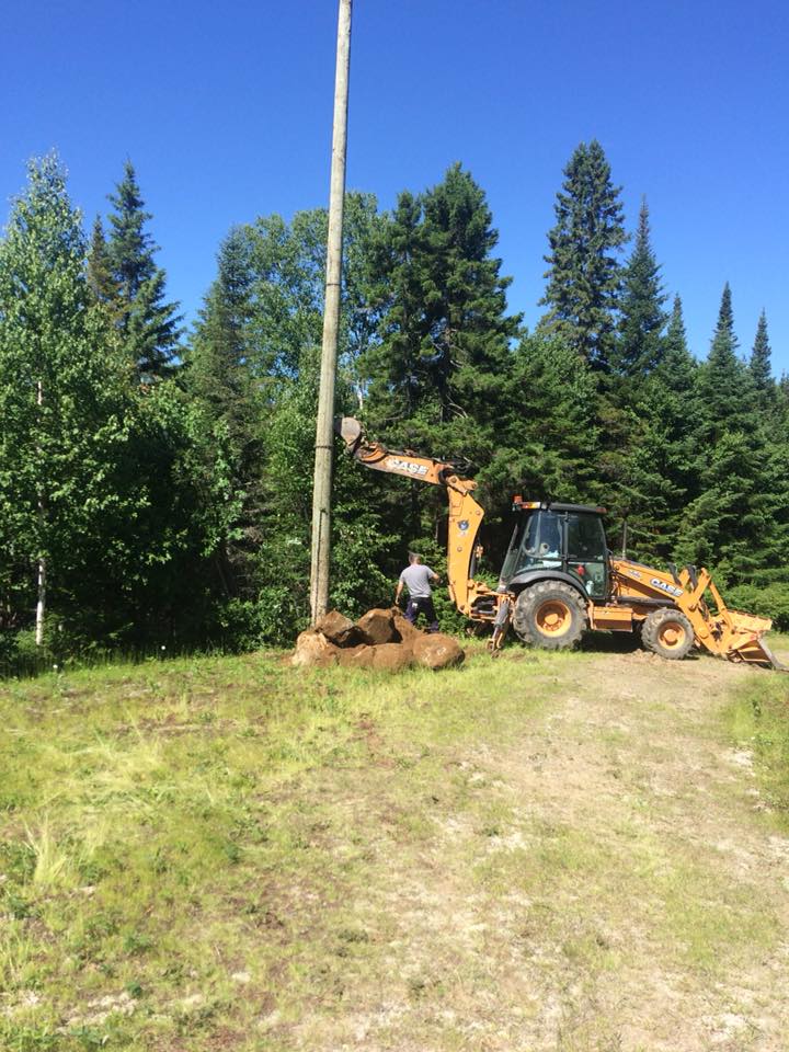 Un homme se tient debout à côté d'un tracteur dans un champ.