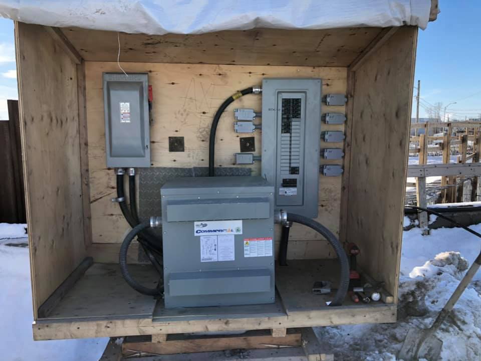 Une boîte en bois contenant du matériel électrique à l'intérieur.