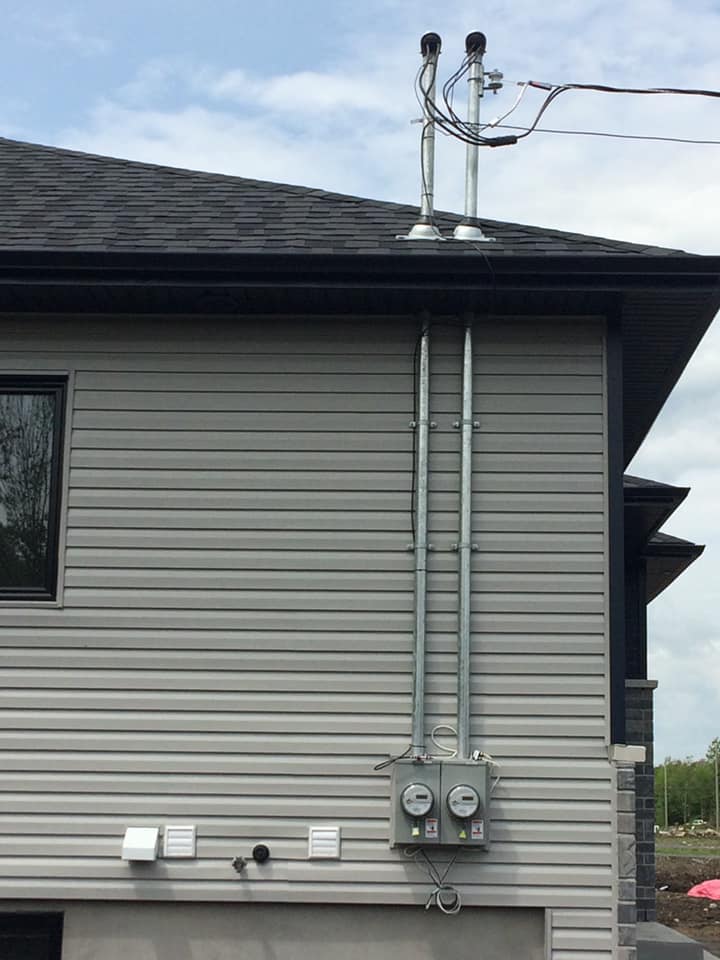 Une maison avec beaucoup de fils électriques sur le côté.