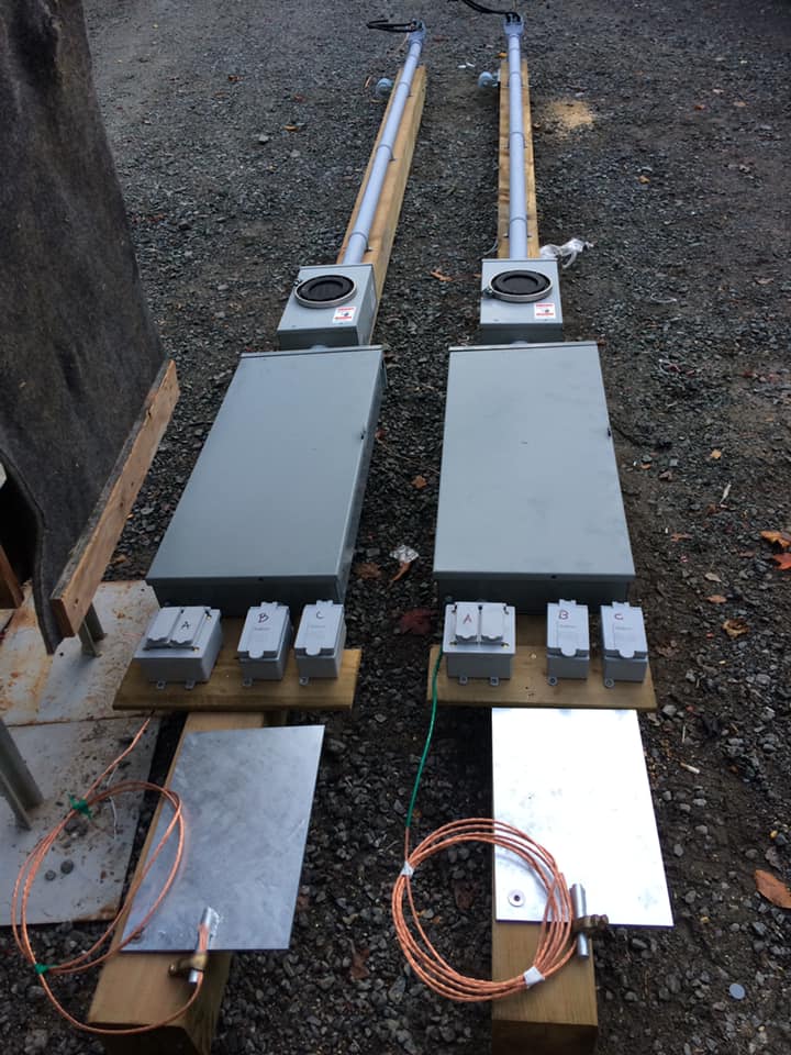 Un tas de boîtiers électriques sont posés les uns sur les autres sur le sol.