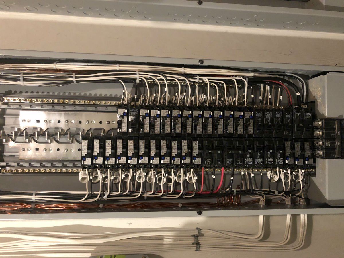 Un gros plan d'un boîtier électrique avec beaucoup de fils qui en sortent.