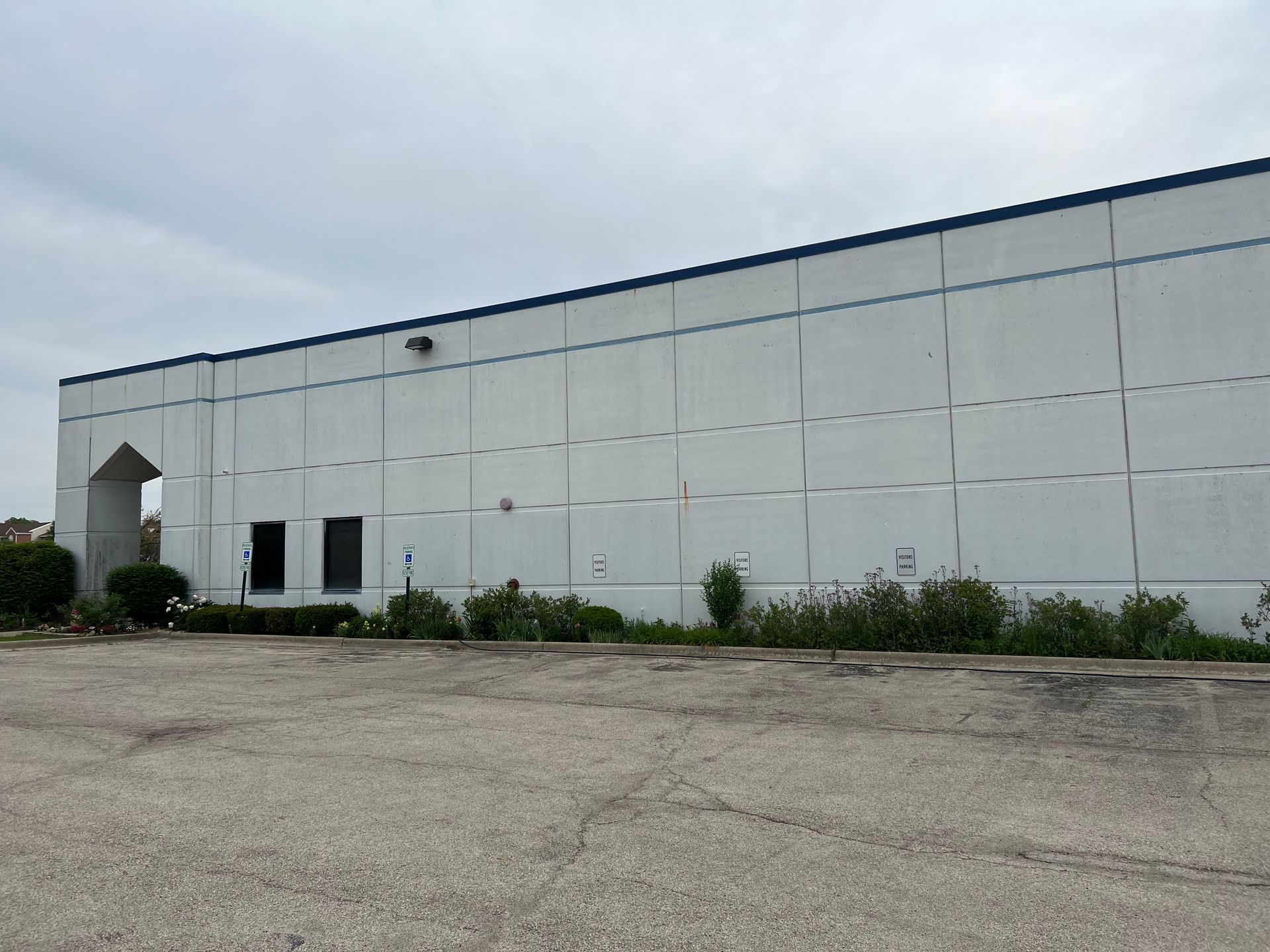 A large white building with a parking lot in front of it.