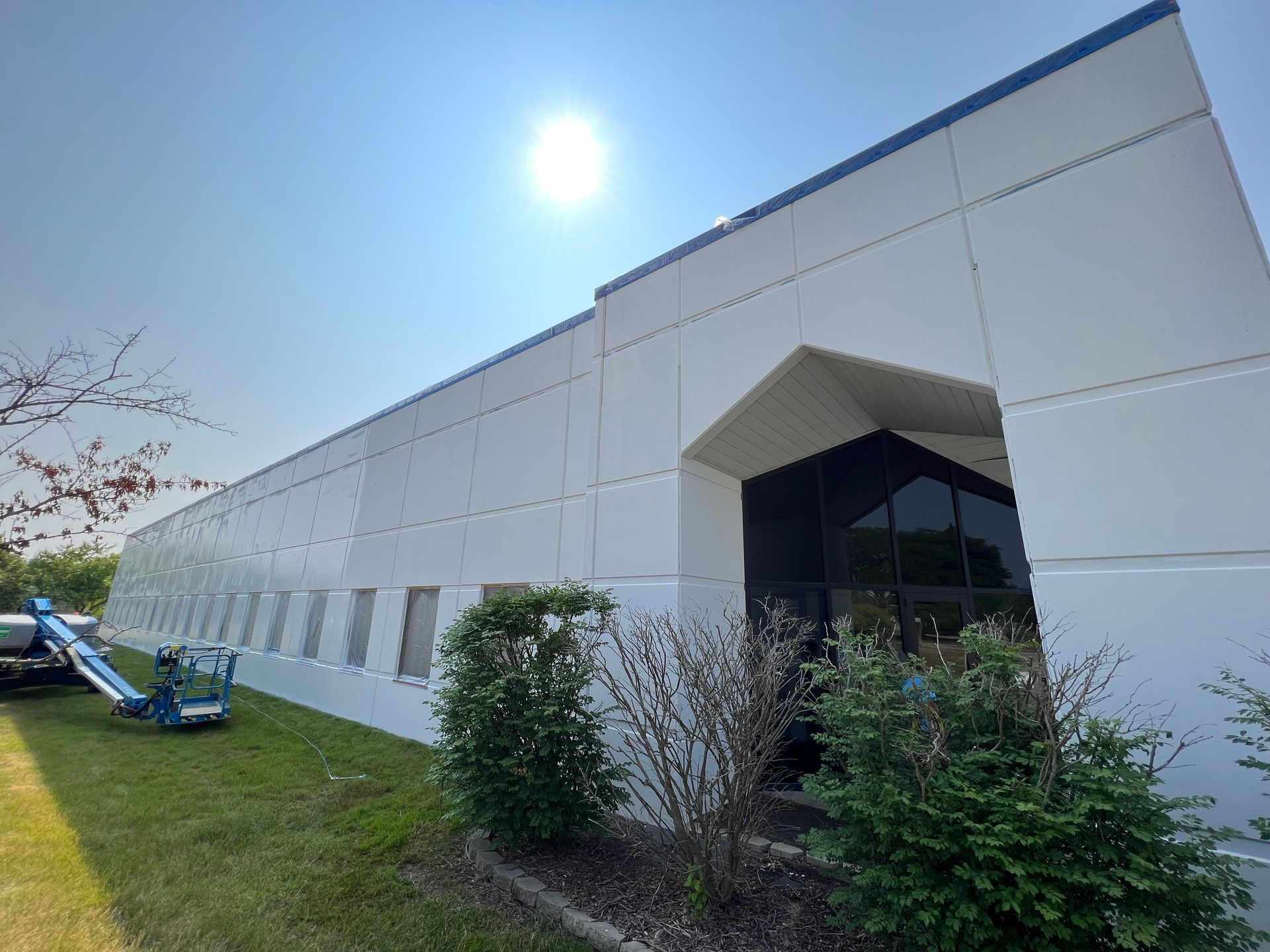 A large white building with a lift in front of it.