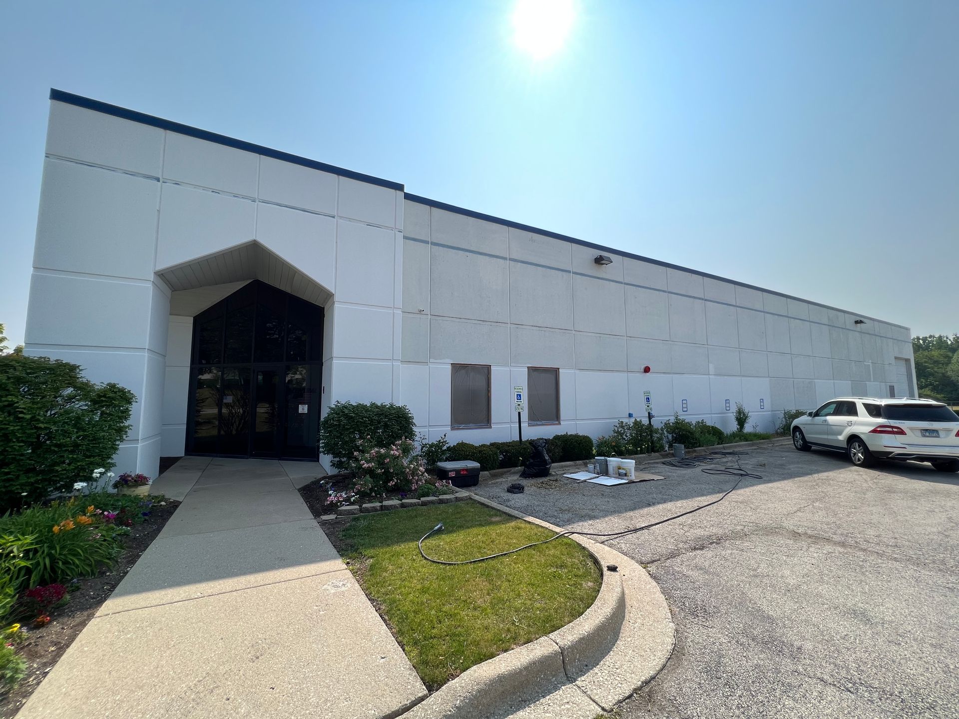 A large white building with cars parked in front of it.