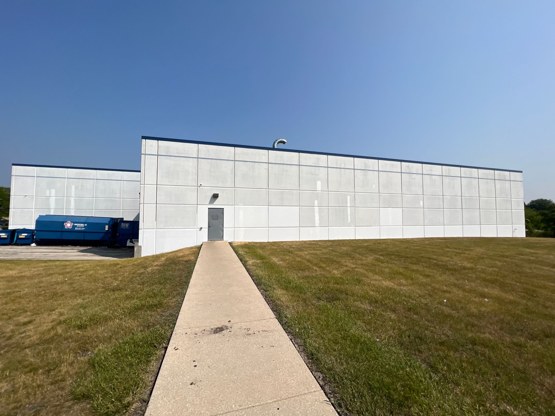 A large white building with a walkway leading to it.