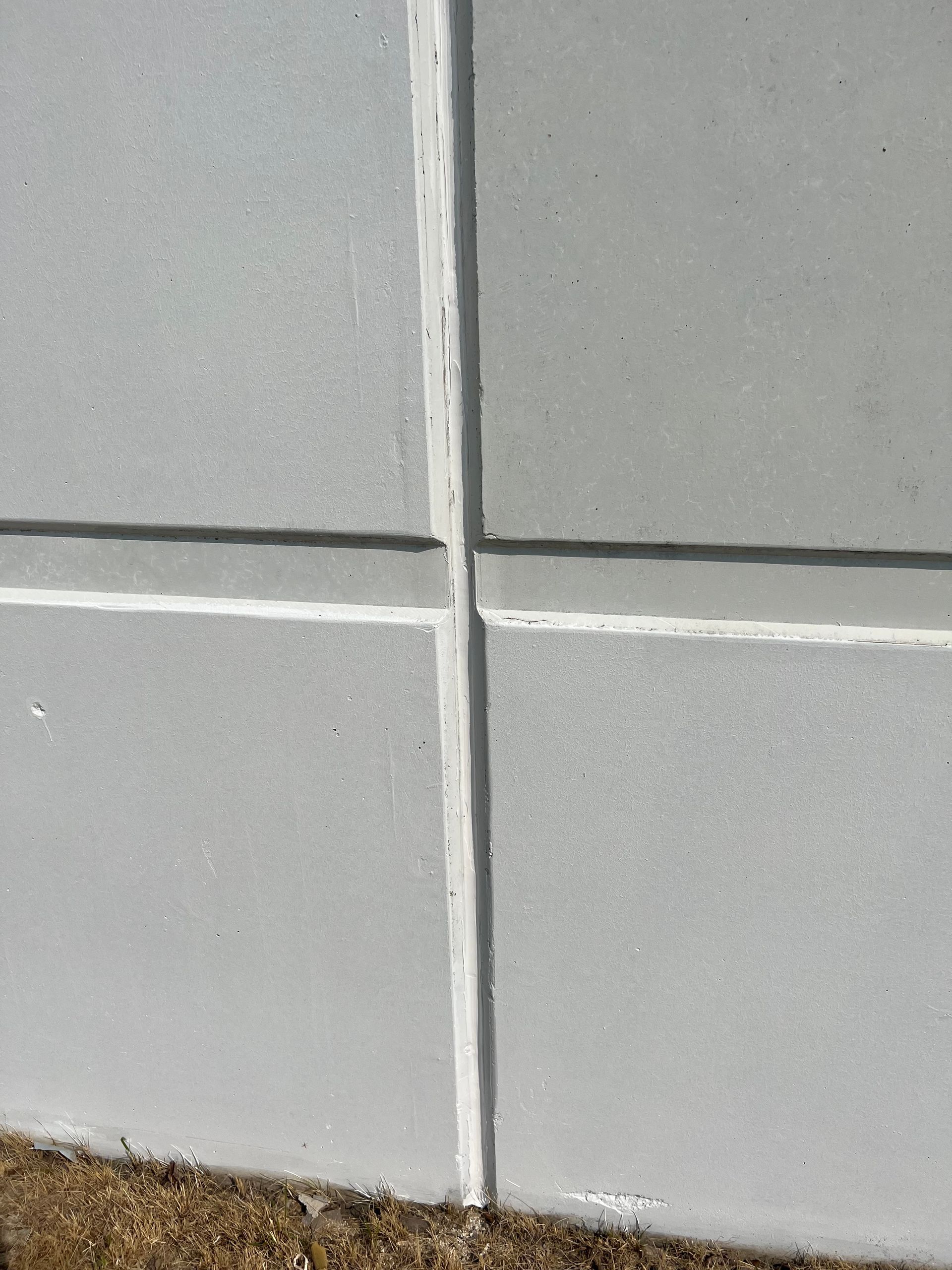 A close up of a white tile wall with a white border.