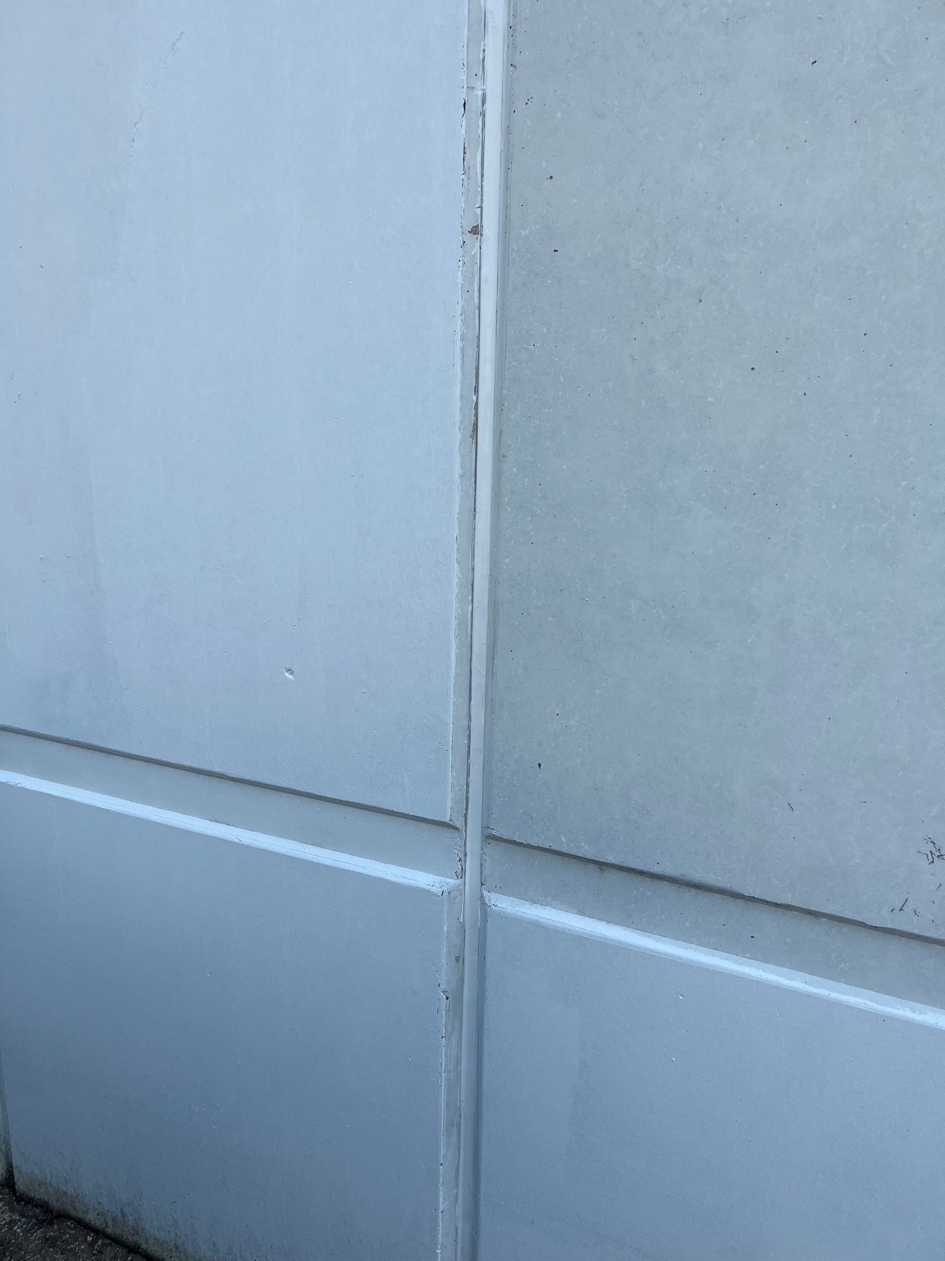 A close up of a white wall with a corner.