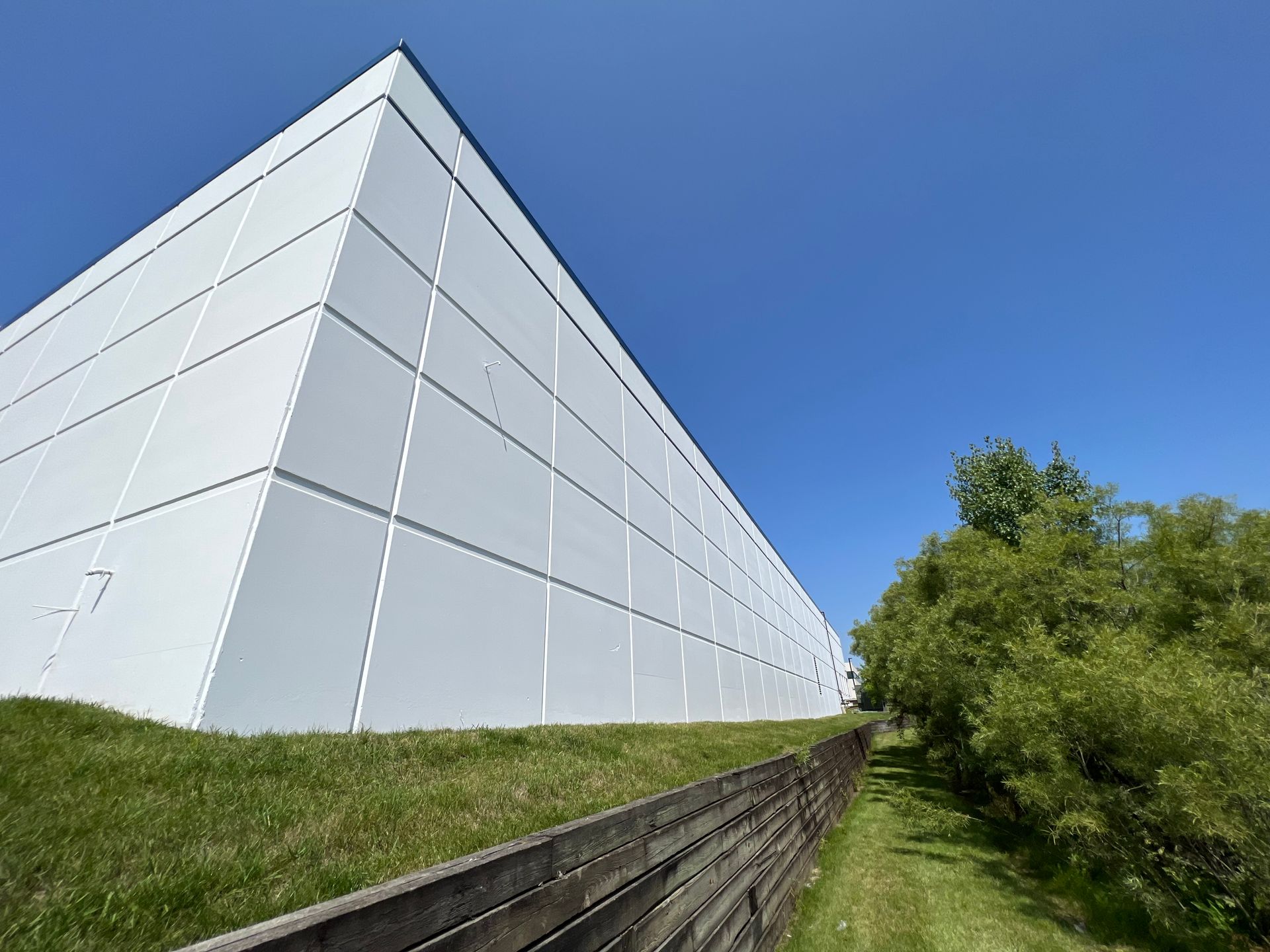 A large white building with a wooden fence in front of it.