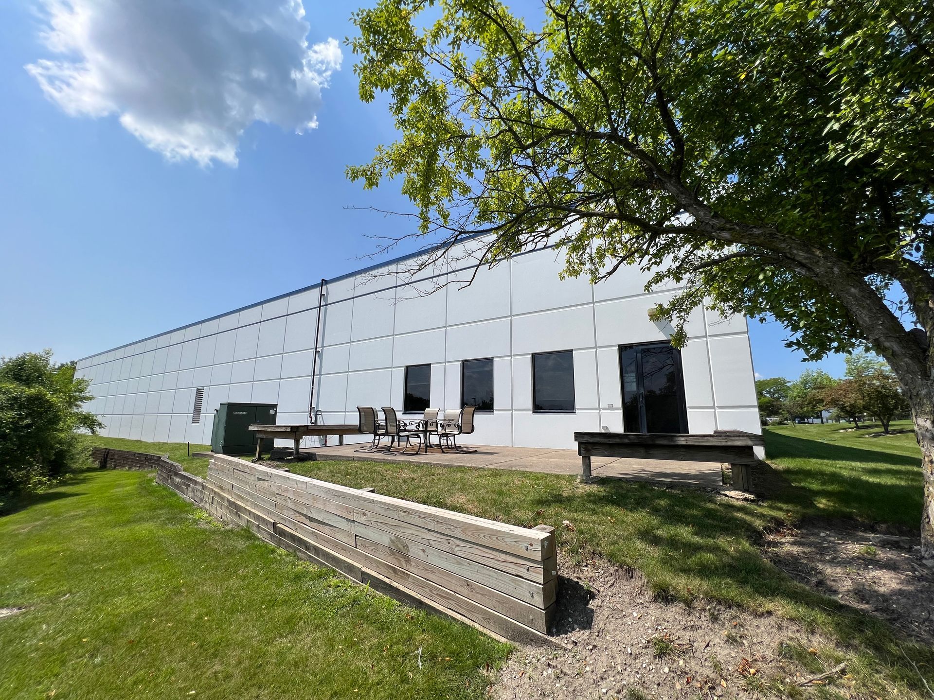 A large white building with a picnic table in front of it.