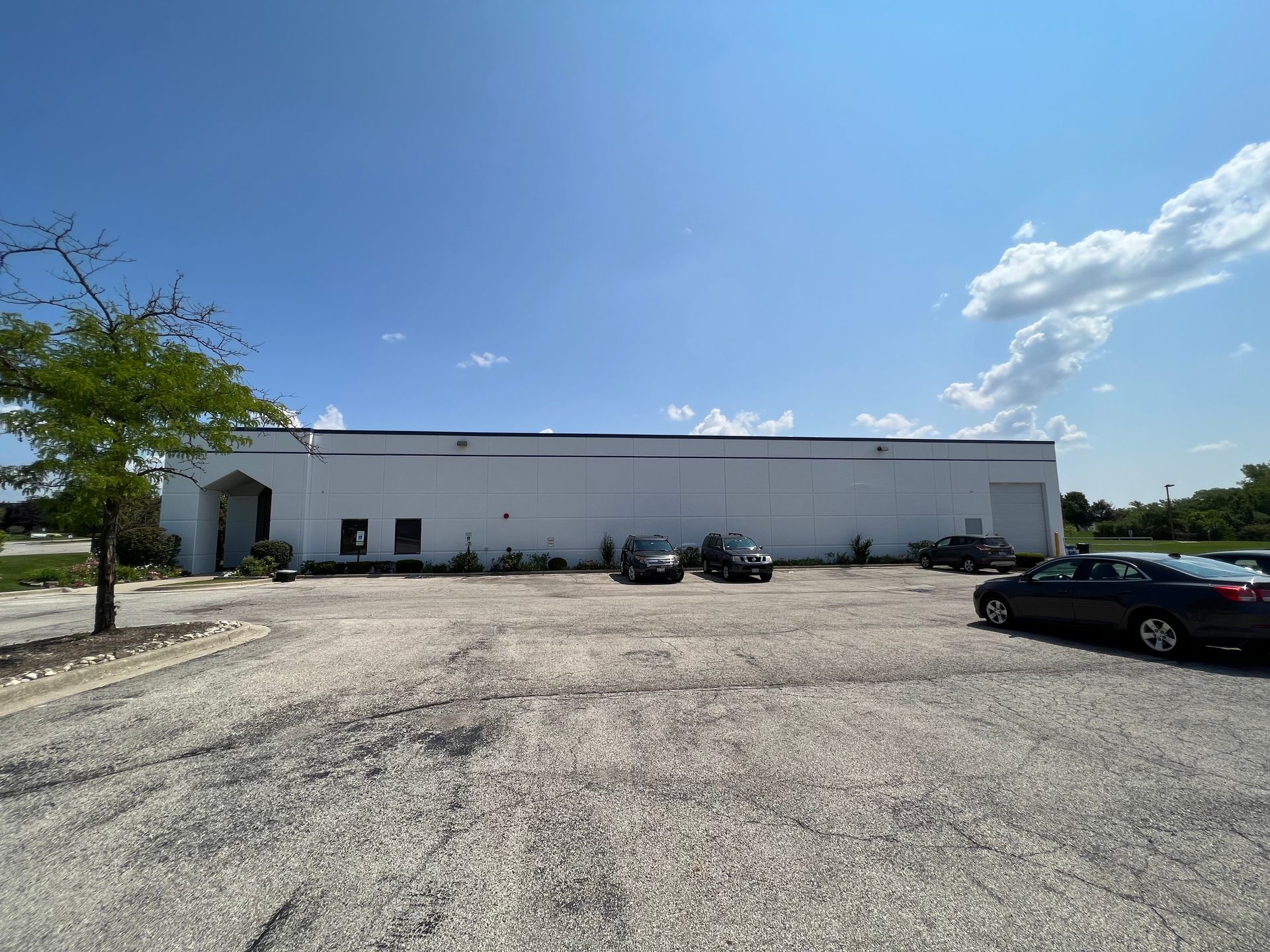 A large white building with cars parked in front of it.