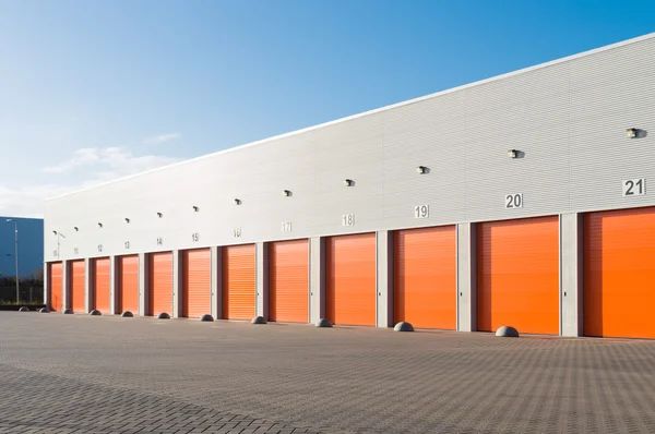 A row of orange garage doors on the side of a building.