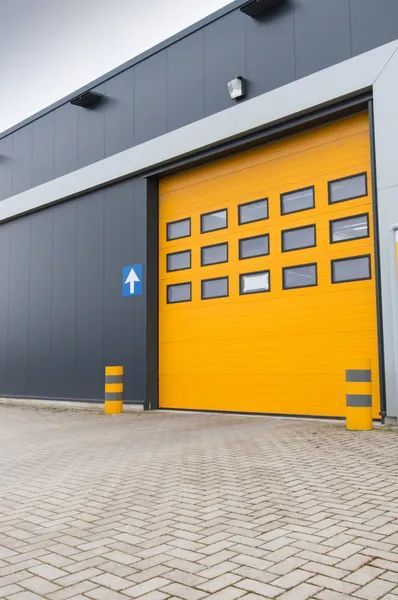 A yellow garage door with a blue arrow pointing to the right