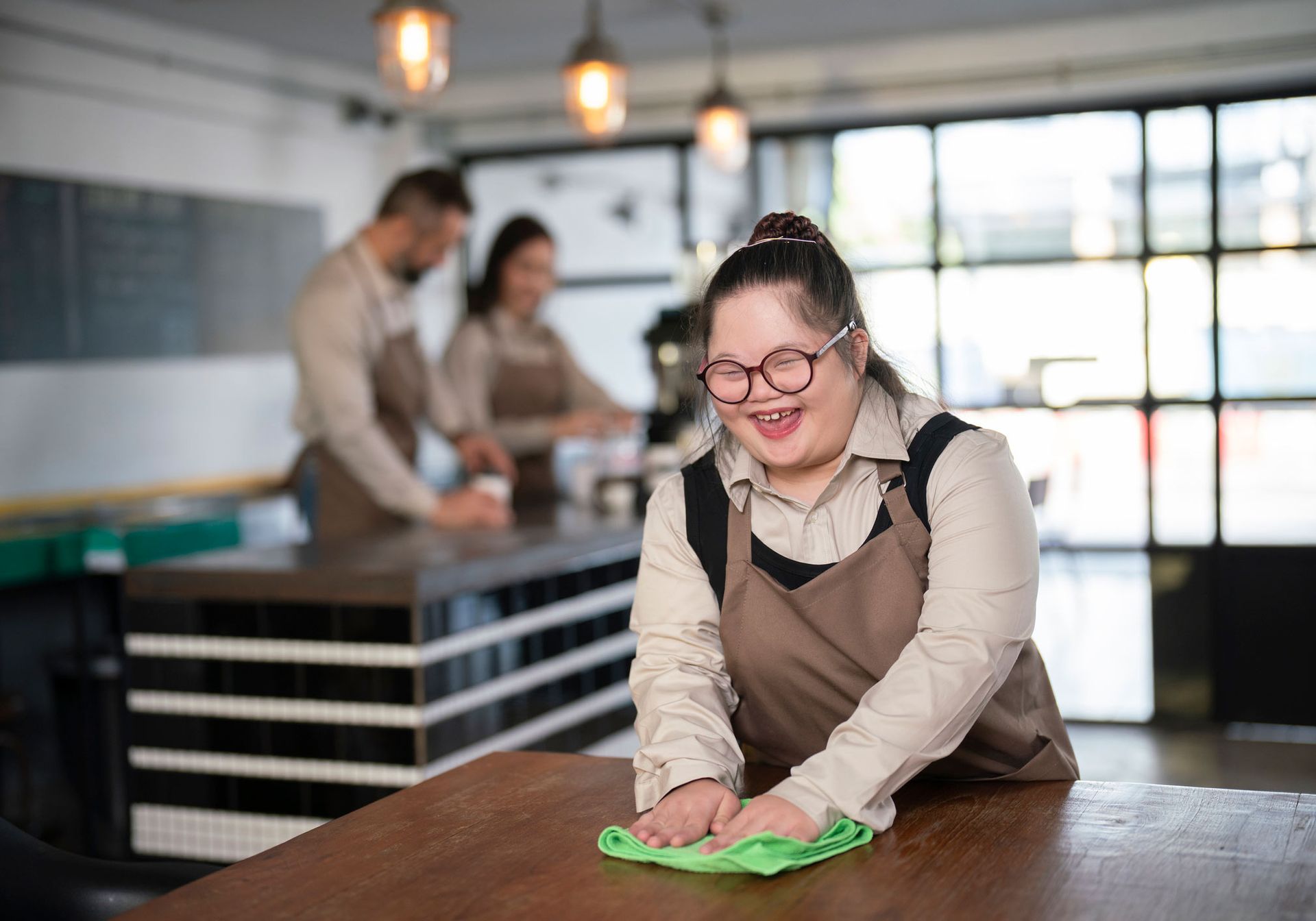 Girl cleaning table in a cafe — Redcliffe, QLD — Achieve Disability Supports