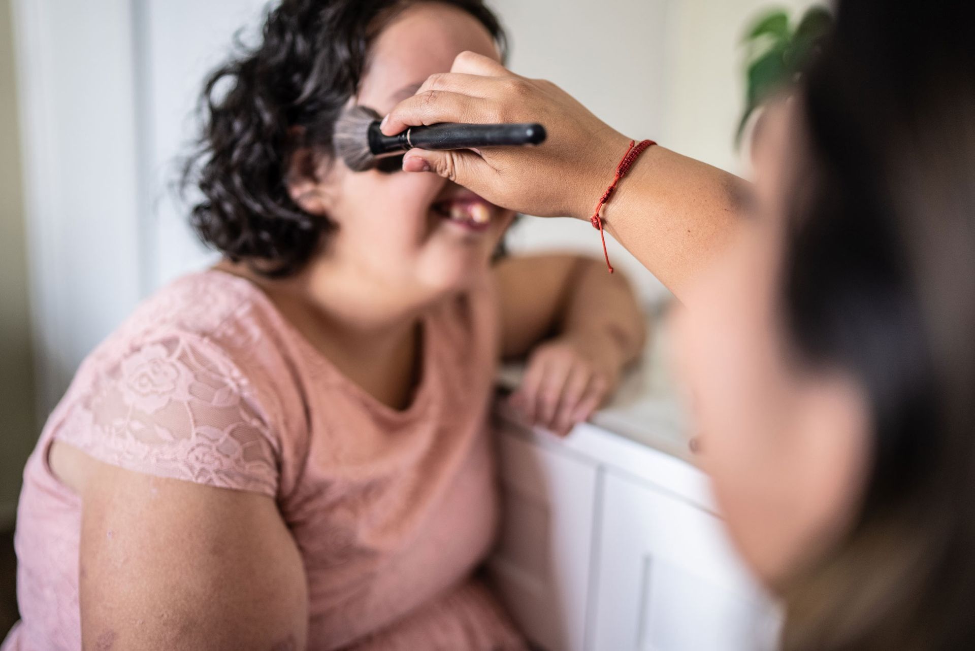 Big sister helping a girl to do her makeup — Redcliffe, QLD — Achieve Disability Supports
