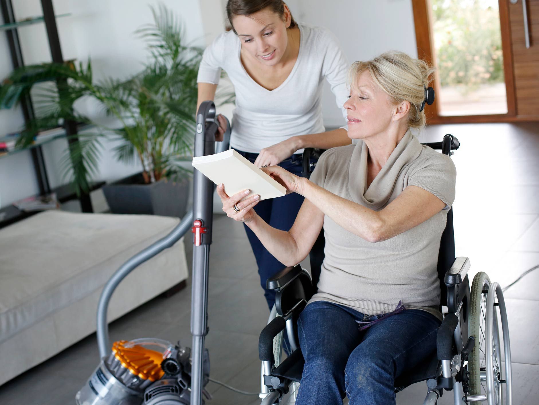 Young woman helping disabled lady at home — Redcliffe, QLD — Achieve Disability Supports