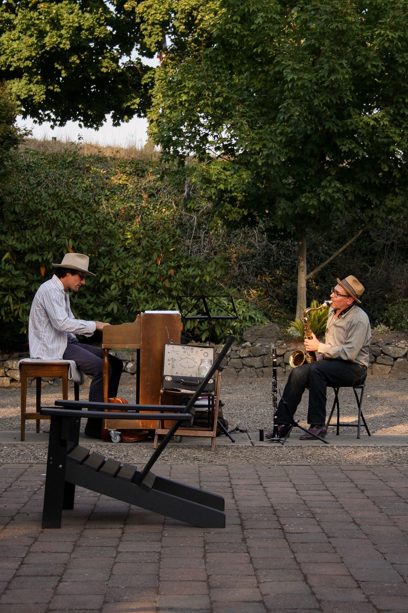 A wooden table topped with bowls of food and a glass of wine