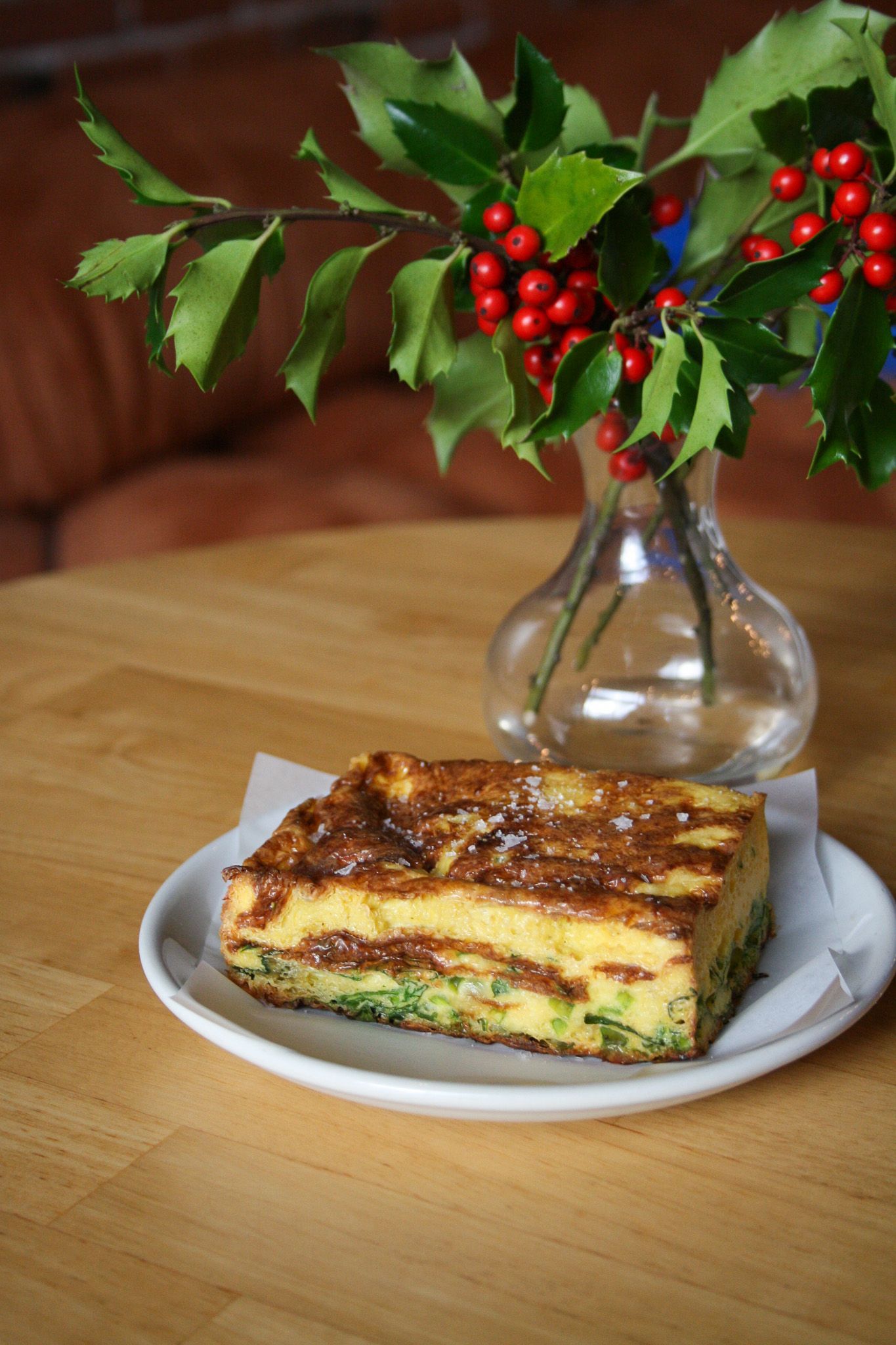Two women are sitting at a table toasting with champagne glasses.