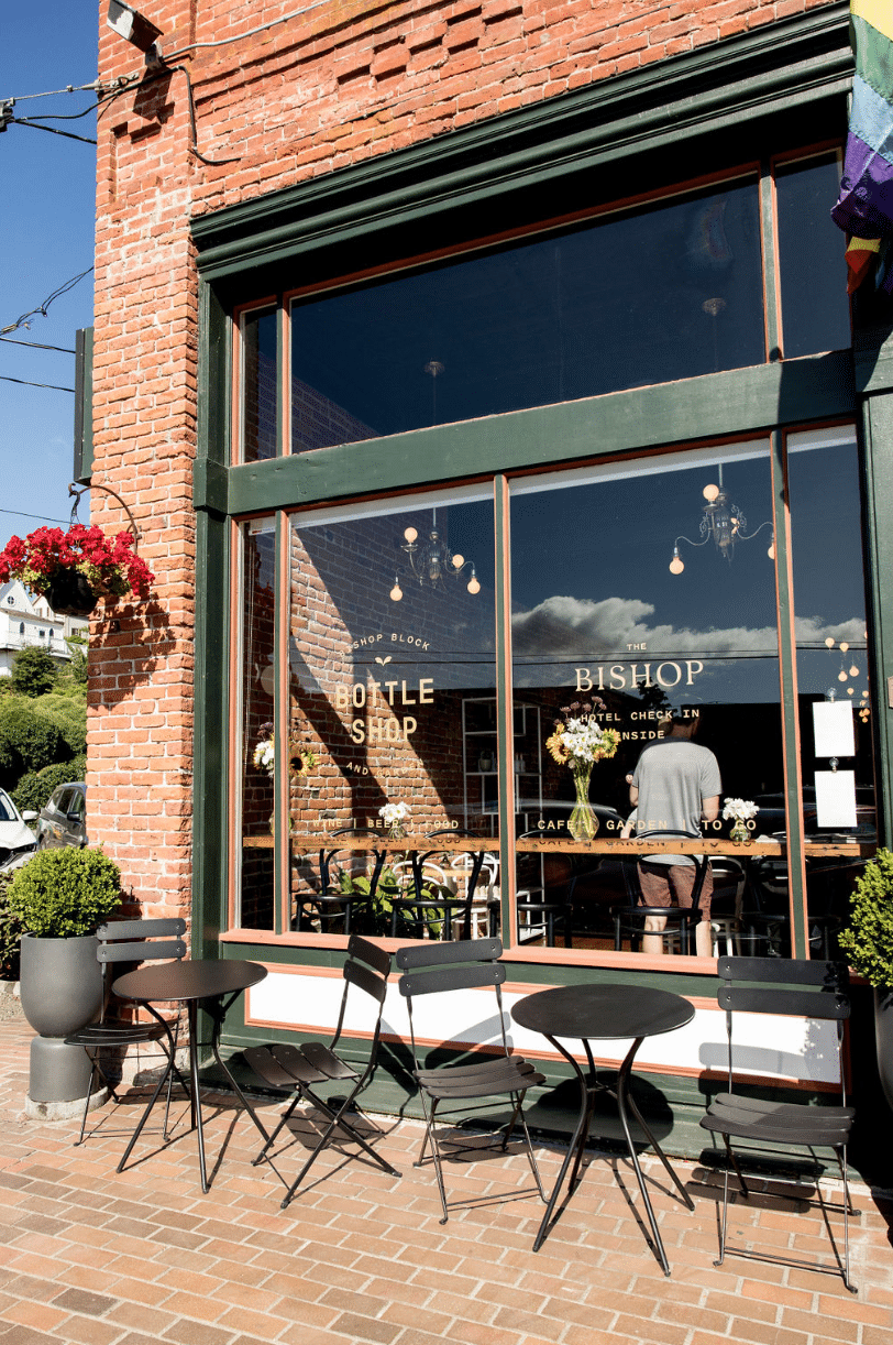 A brick building with tables and chairs in front of it.