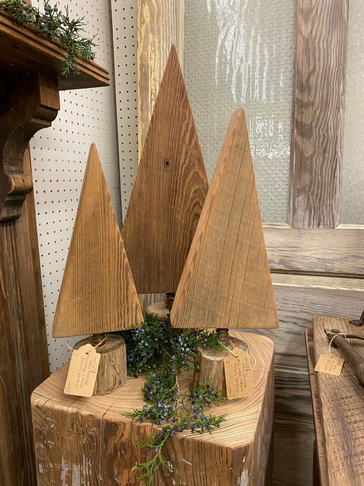 Three wooden trees are sitting on top of a wooden block.