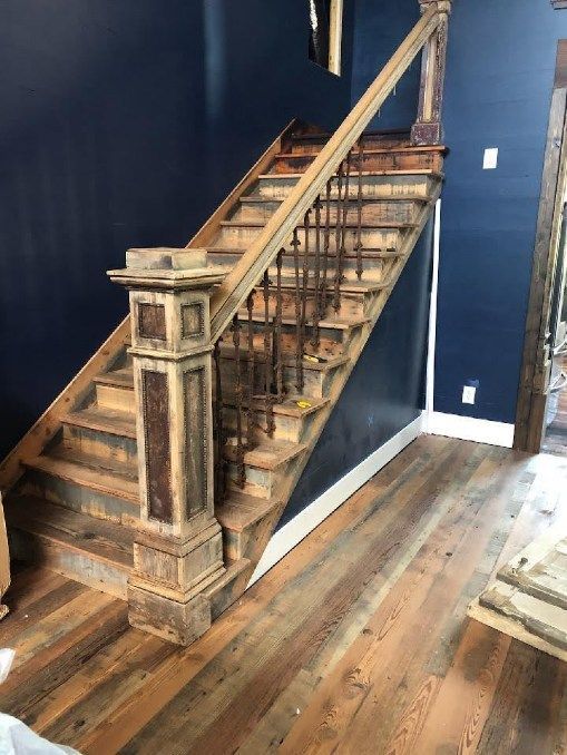 A wooden staircase with a metal railing in a living room.