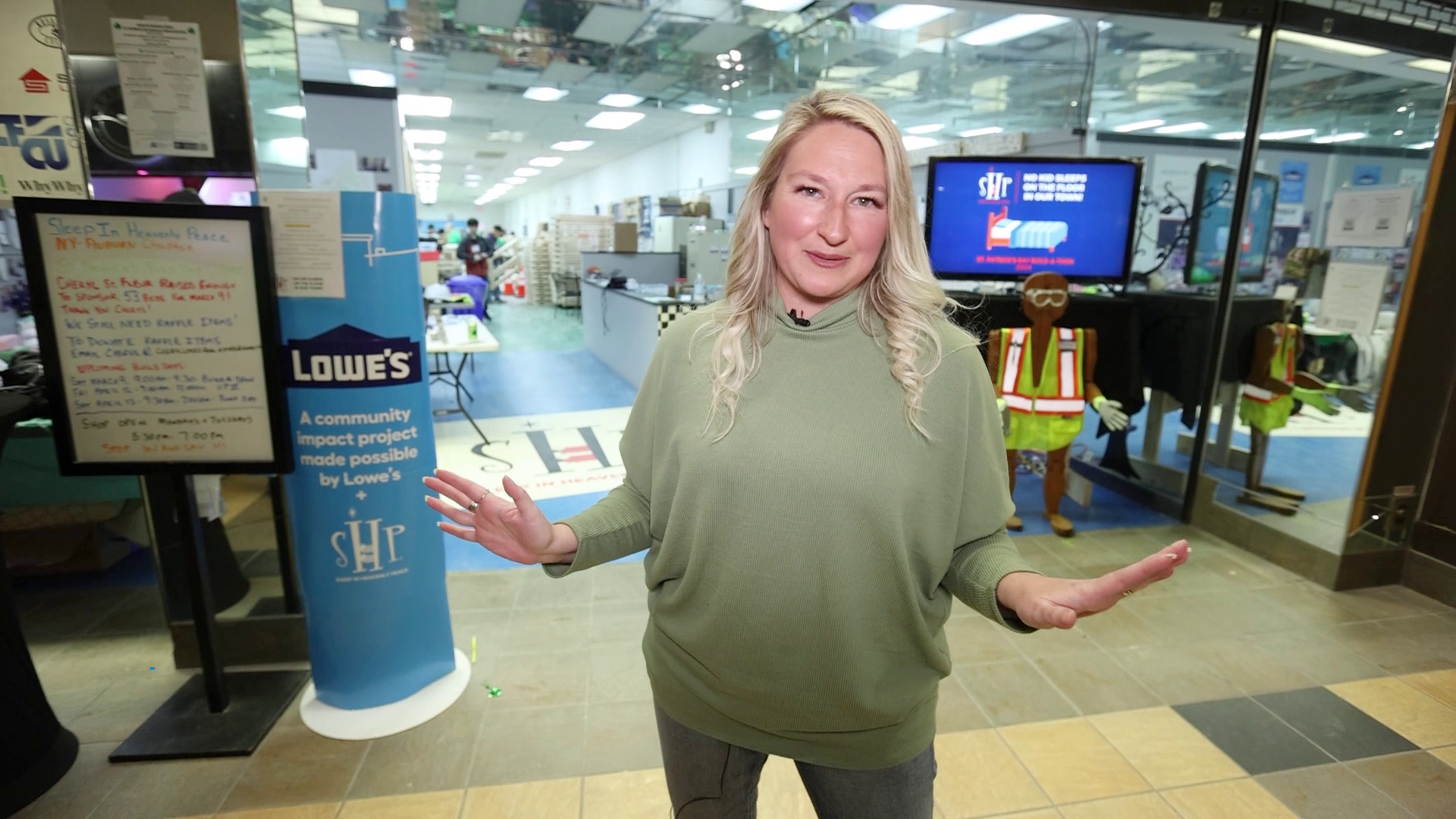 A woman is standing in front of a building with a sign that says hhb on it.