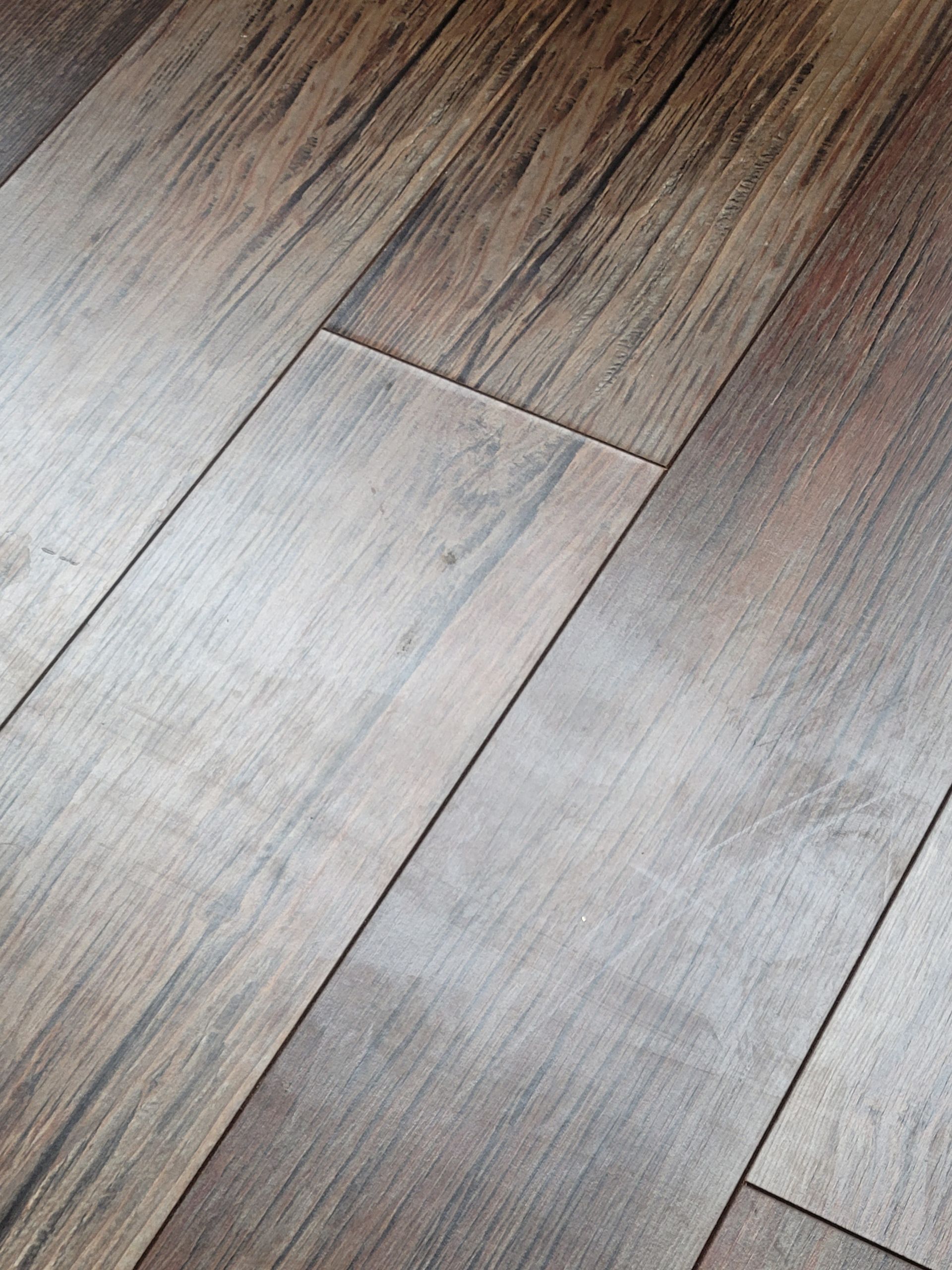 A close up of a wooden floor with a shiny finish.