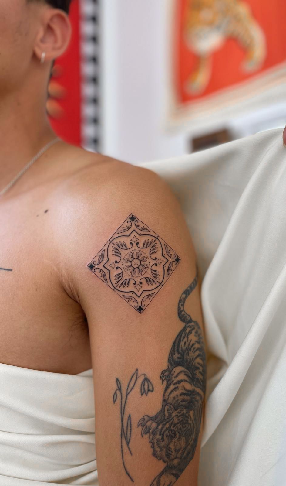 Uma mulher tem uma tatuagem no ombro e no braço.