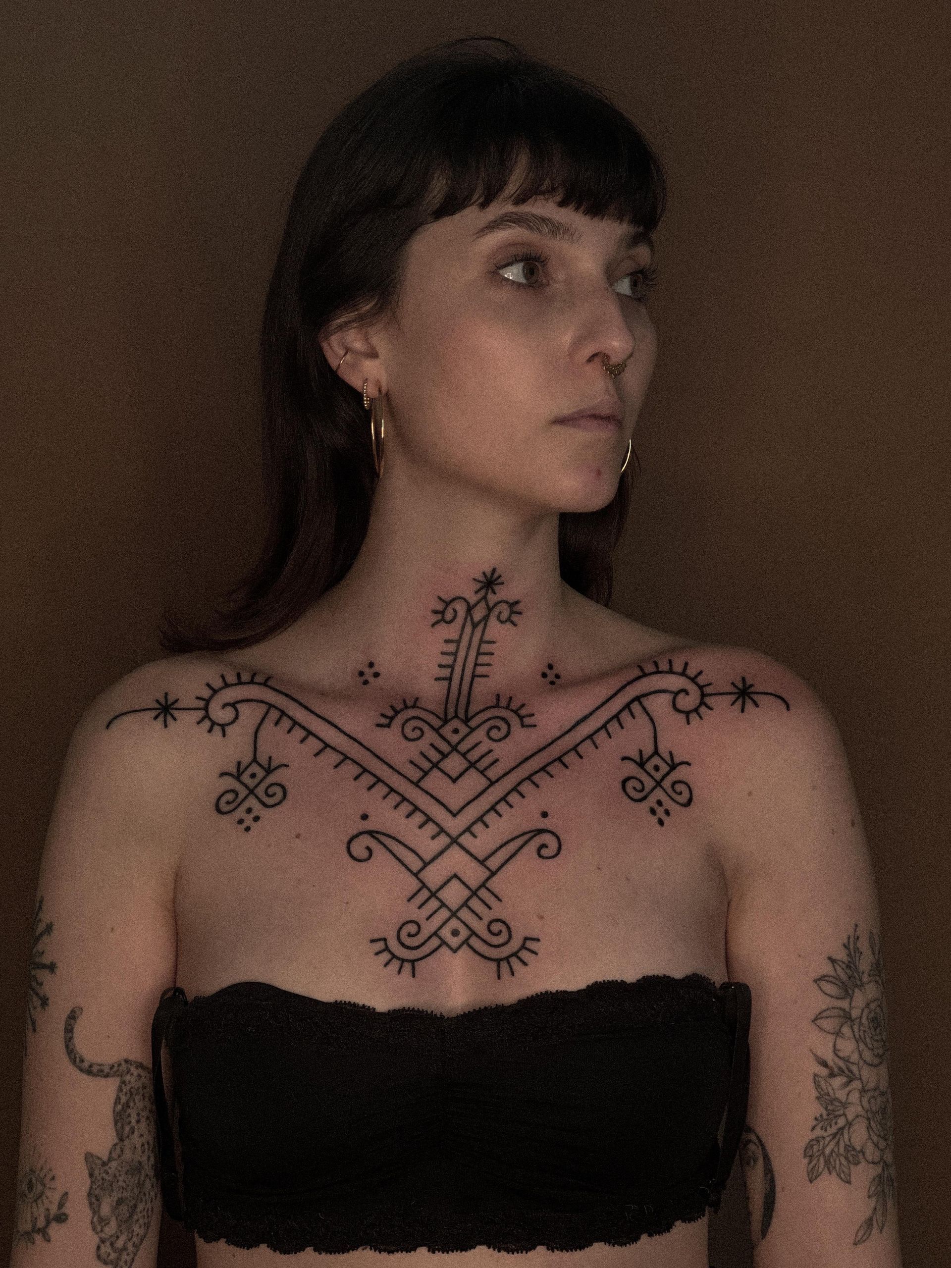 Uma mulher com uma tatuagem no peito e no pescoço