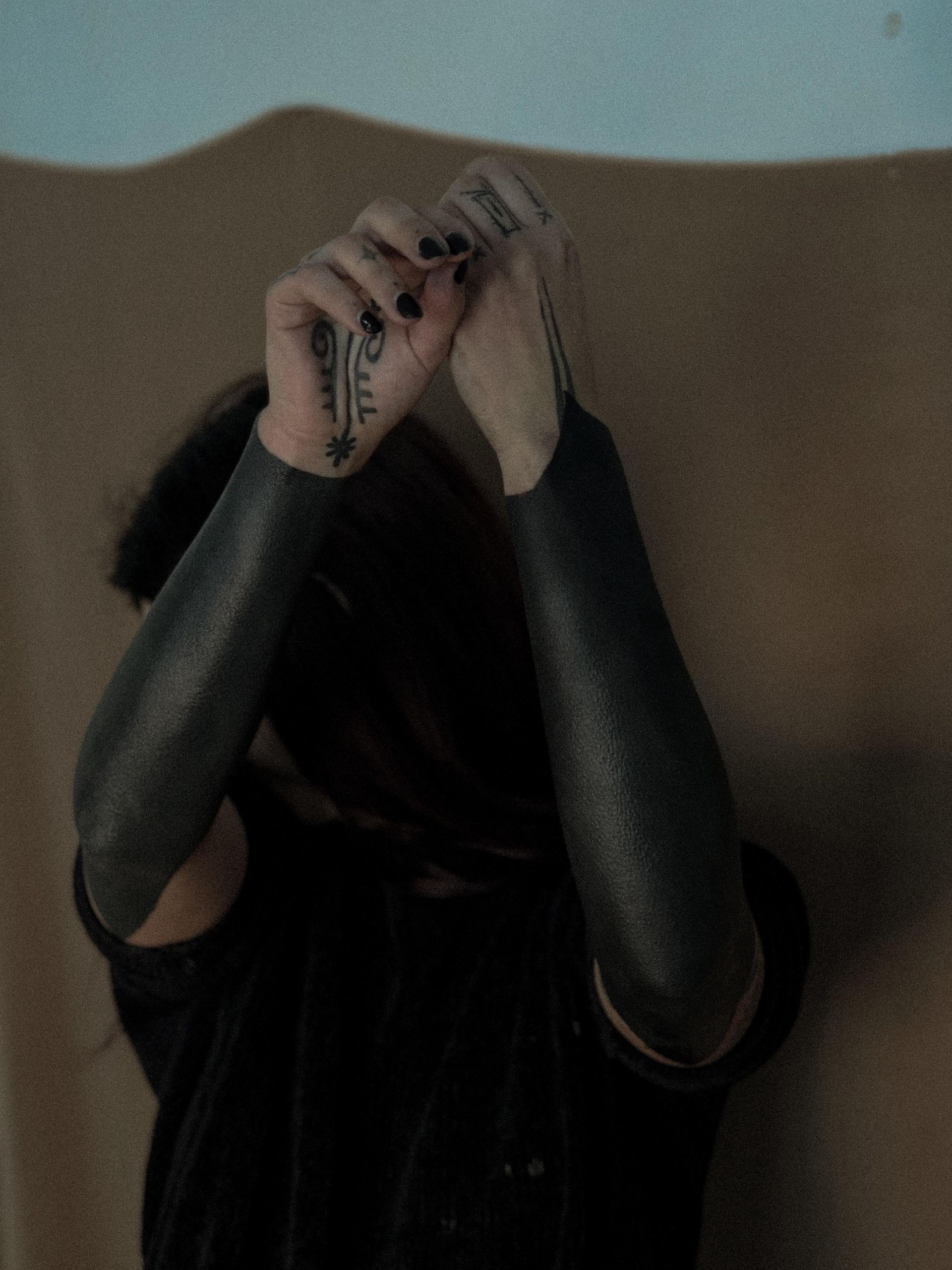 Uma mulher com mangas pretas e uma tatuagem no braço