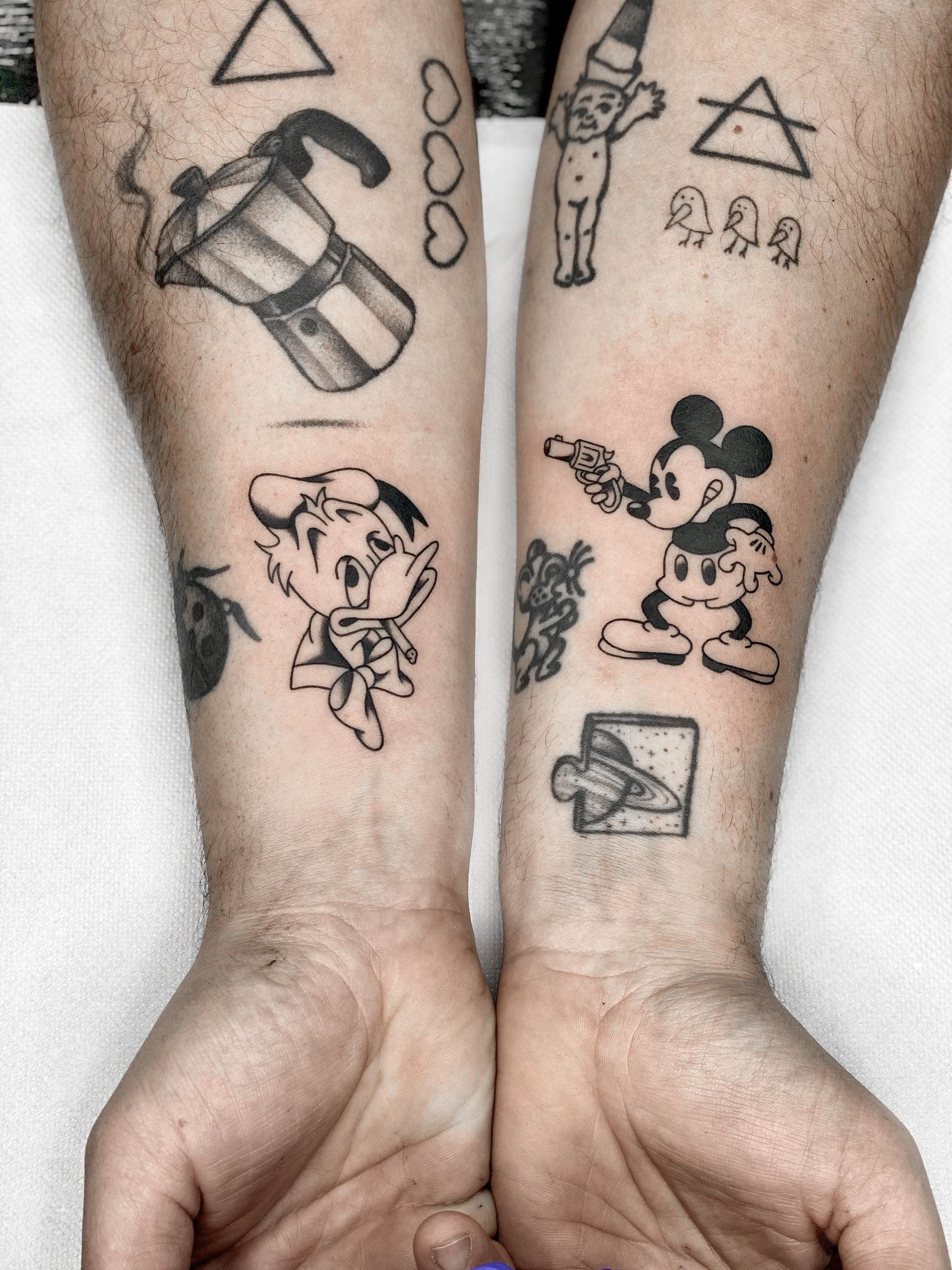 Uma pessoa tem uma tatuagem do Mickey Mouse no antebraço