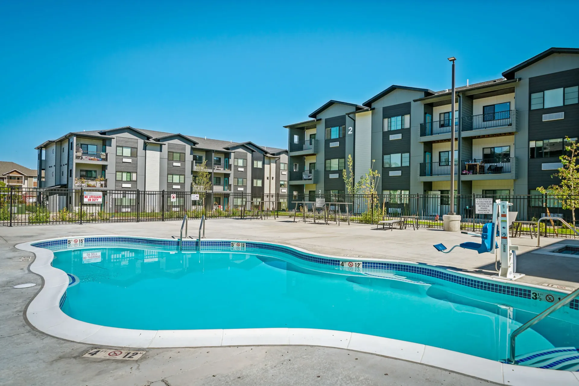 Outdoor communal pool with apartment buildings in the background.