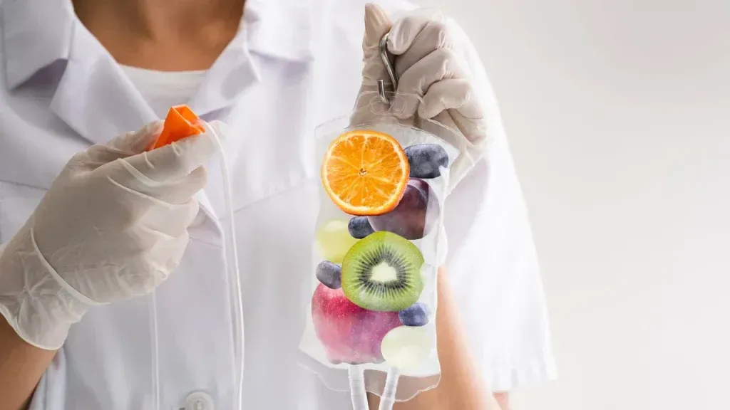 Medical professional holding IV bag filled with colorful fruit.