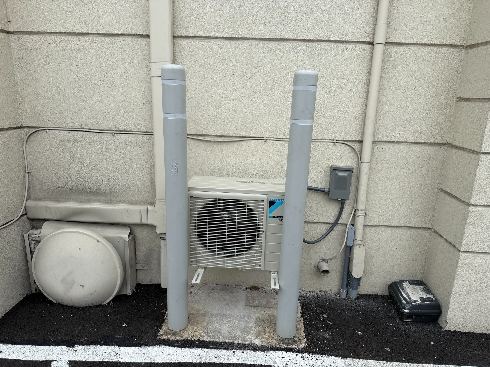 Damaged outdoor AC unit next to house with exposed internal components and fan.