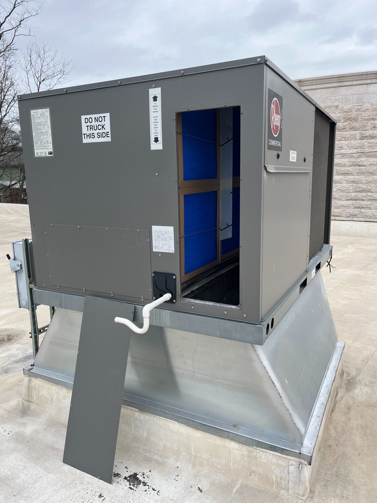 Rooftop HVAC unit with a gray enclosure, blue interior panels, and a silver base, mounted on a flat roof.